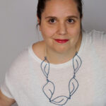 creative casual work from home style: t-shirt and top knot with a Matisse-inspired necklace