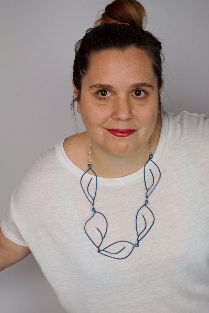 creative casual work from home style: t-shirt and top knot with a Matisse-inspired necklace