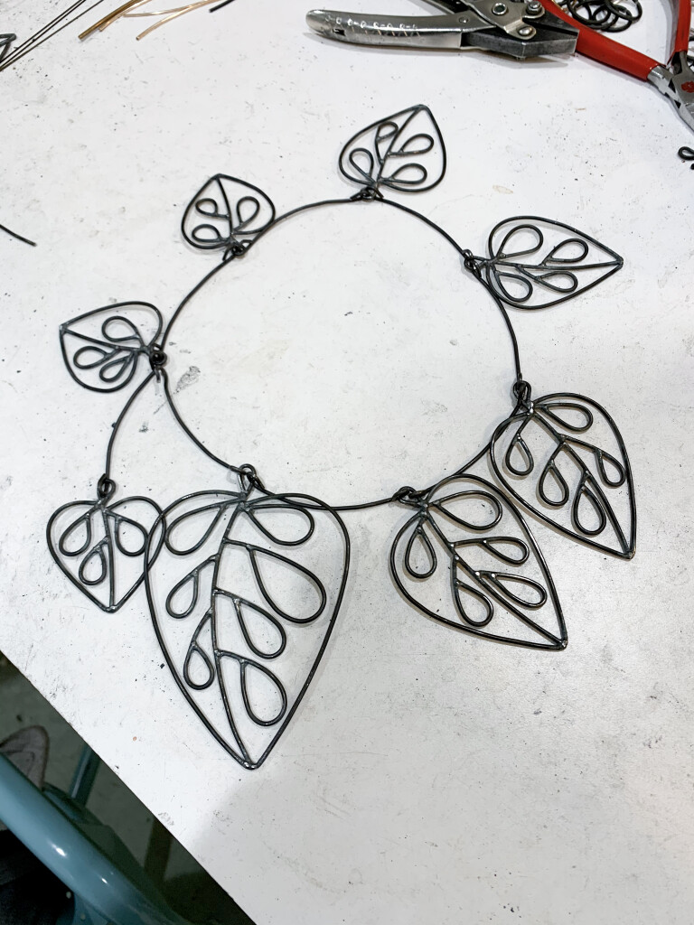 work in progress in the studio of metalsmith megan auman - necklace inspired by monstera adansonii and alexander calder