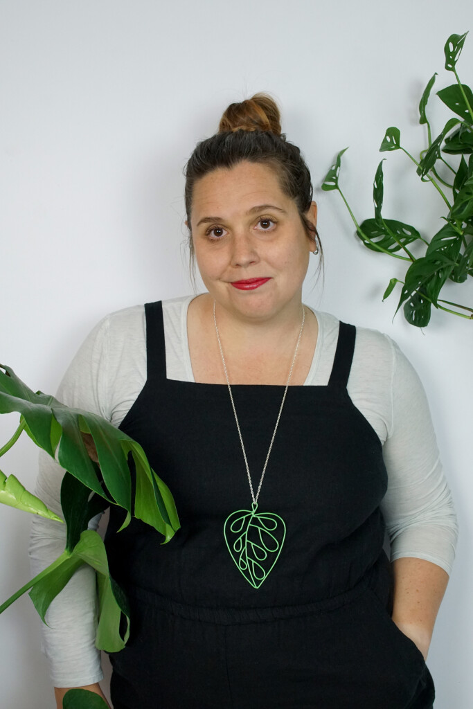 work from home style: black jumpsuit and plant inspired pendant