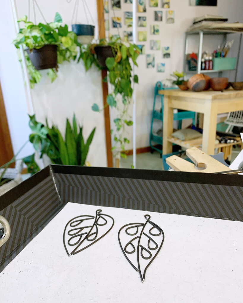 a scene from the studio of metalsmith Megan Auman featuring botanically inspired jewelry and lots of plants