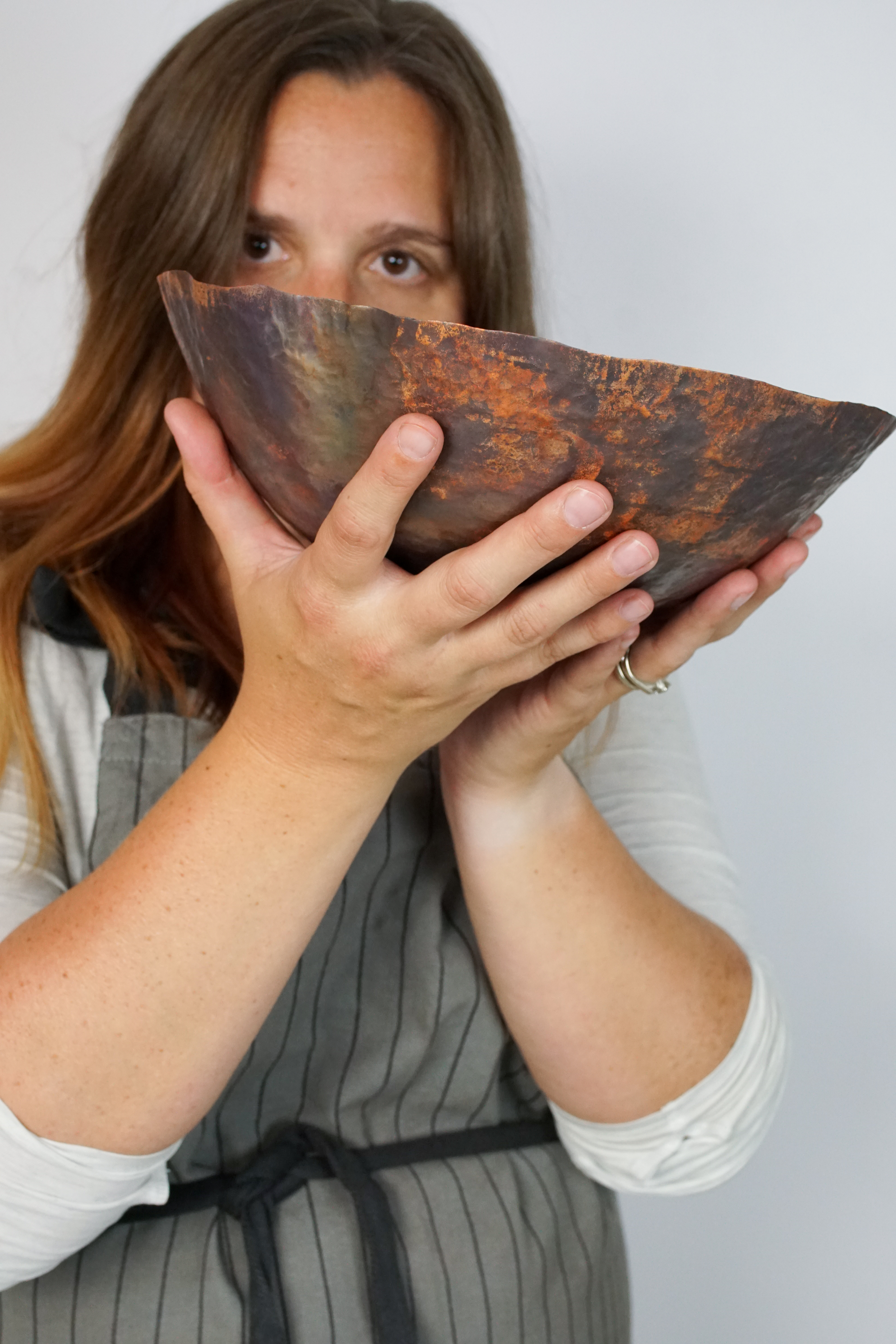 metalsmith megan auman with a raised copper bowl in progress