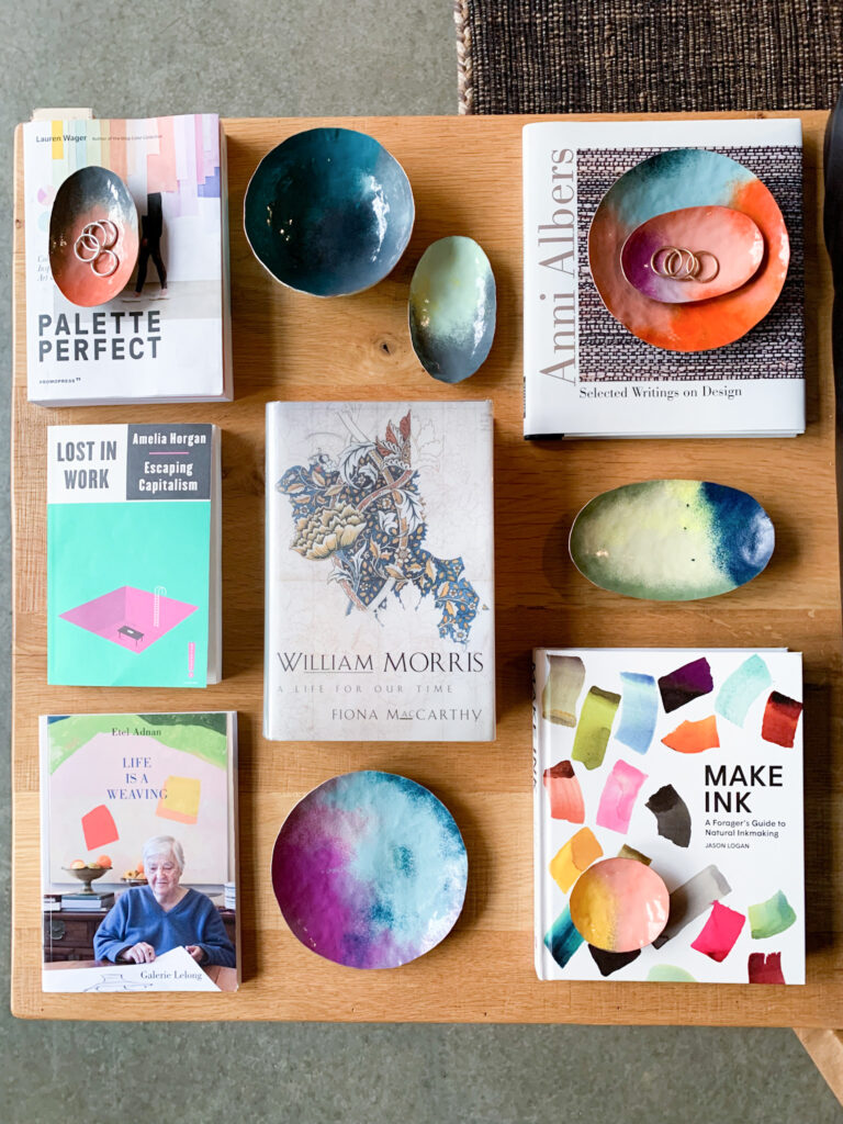 books on art and decorative copper dishes displayed on a side table in a cabin in the woods