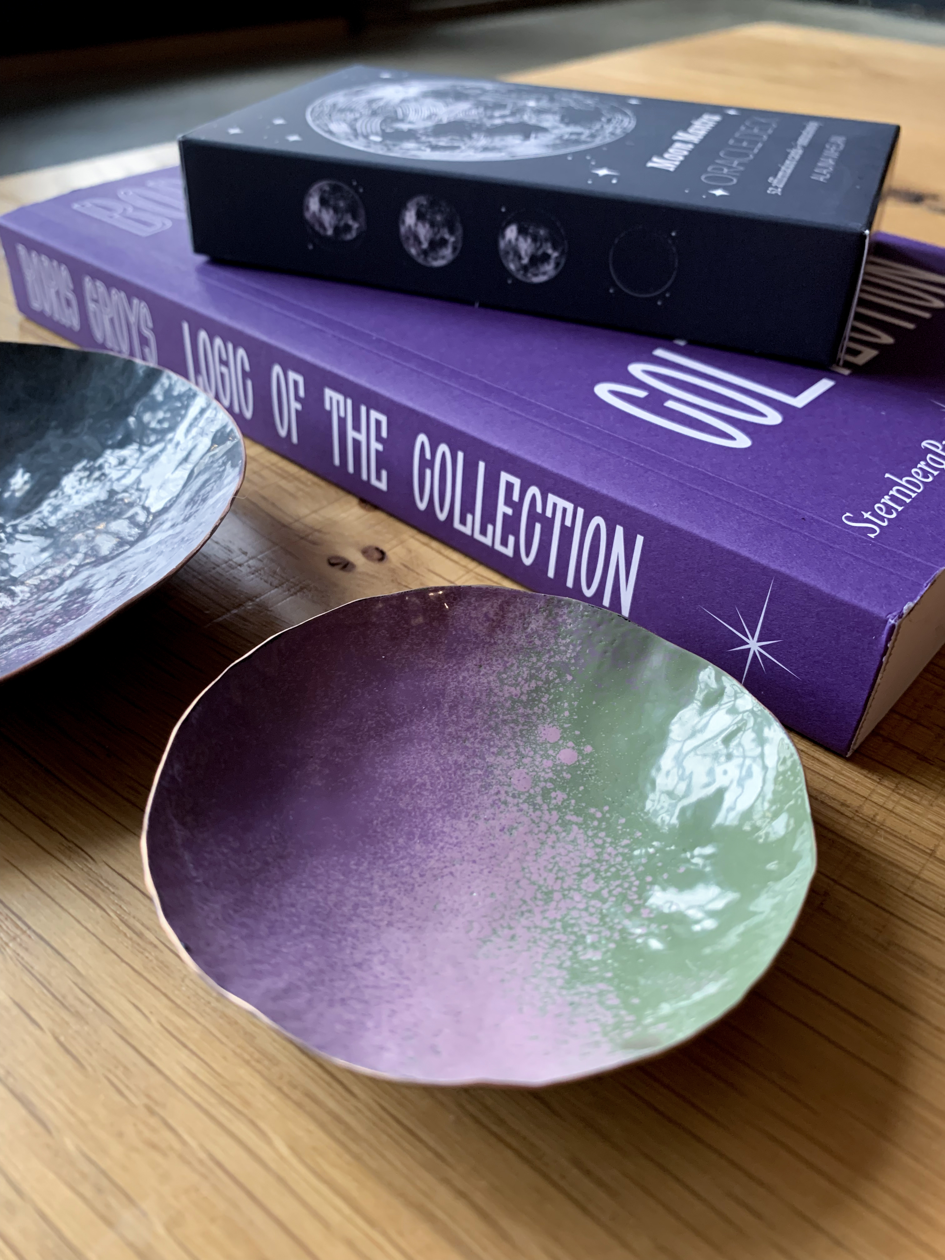 colorful decorative metal dishes, book, and moon mantra oracle deck