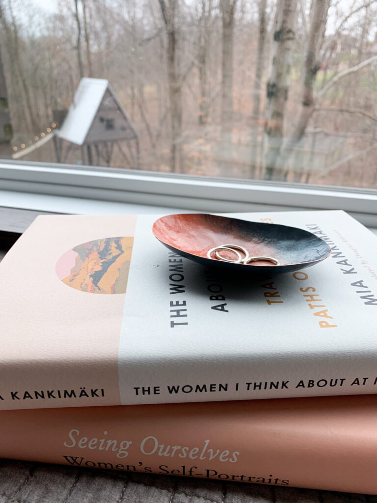 colorful metal ring dish on books and treehouse cabin