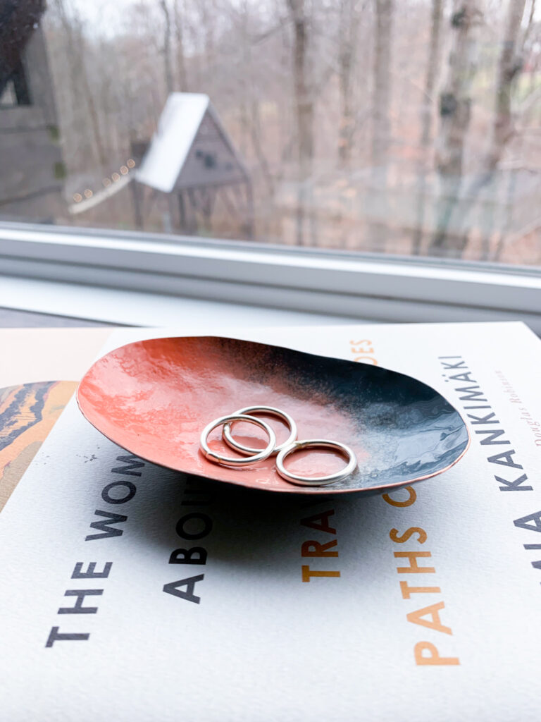 colorful metal ring dish on books and treehouse cabin