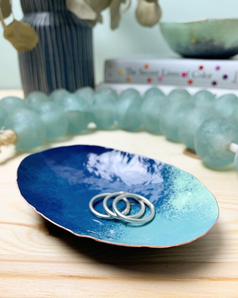 nightstand styling - colorful copper ring dish and bowl, glass beads, vase, books