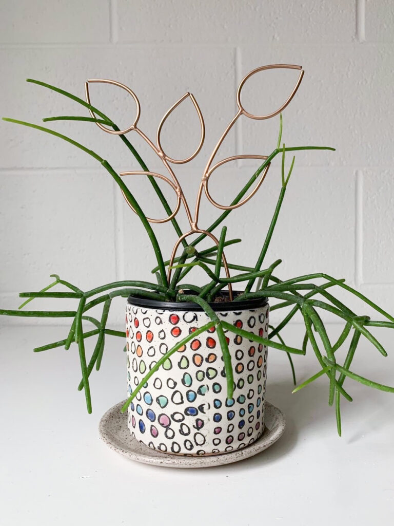 handmade bronze plant stake in handmade ceramic planter with pencil cactus