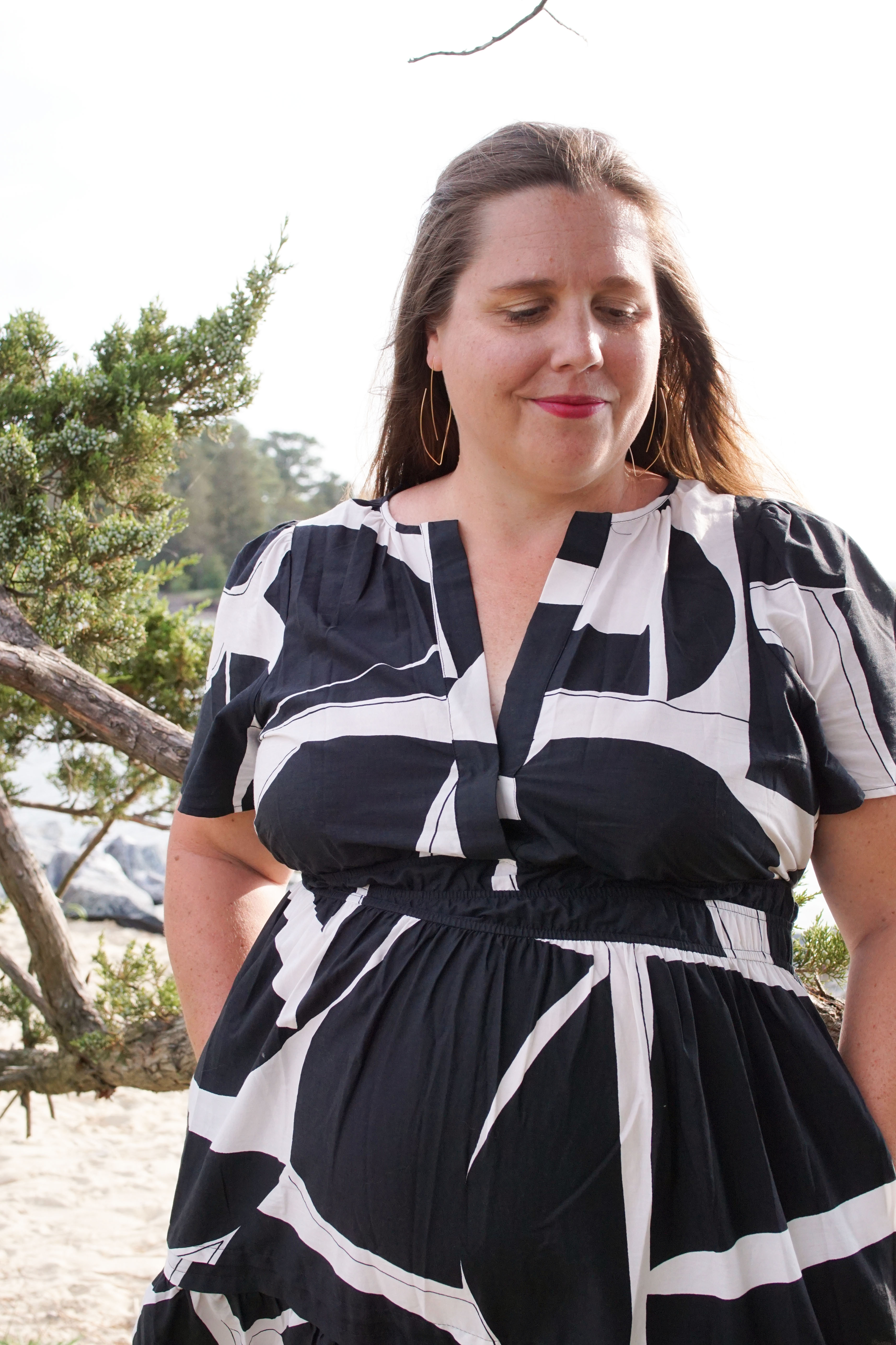 black and white dress on a beach with gold threader hoop earrings