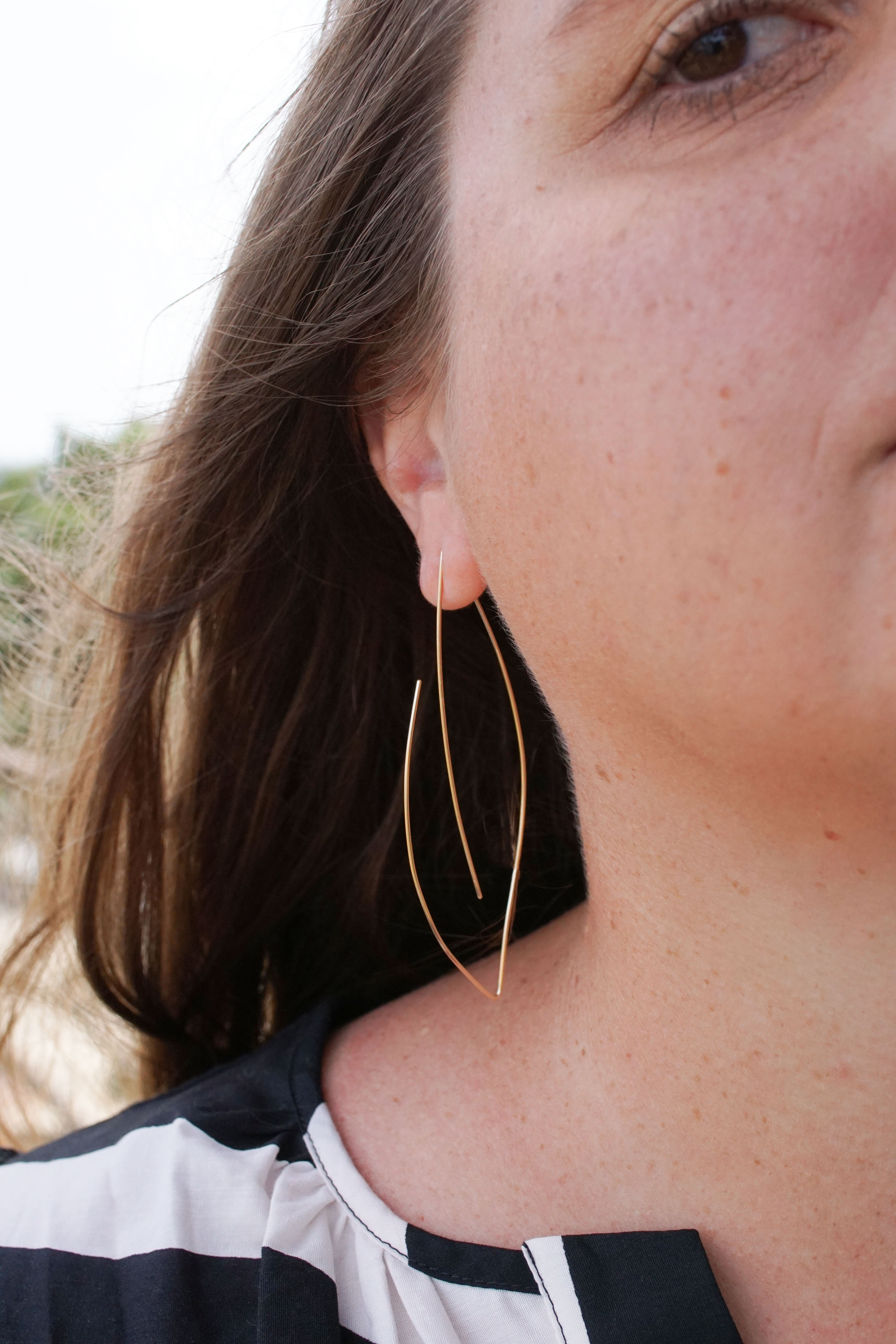 black and white dress on a beach with gold threader hoop earrings