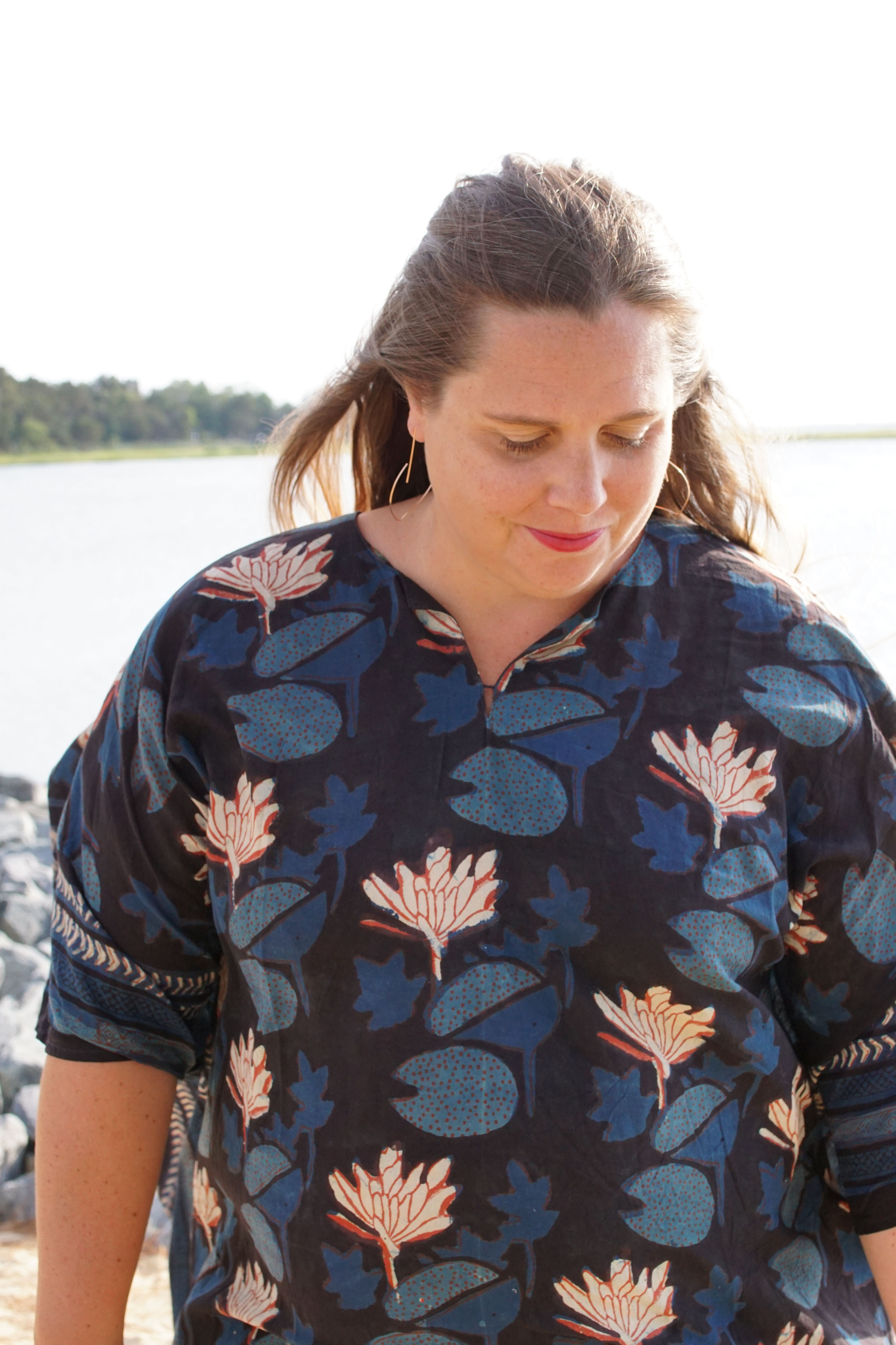 woman wearing block-printed kaftan and rose gold threader hoop earrings at the beach