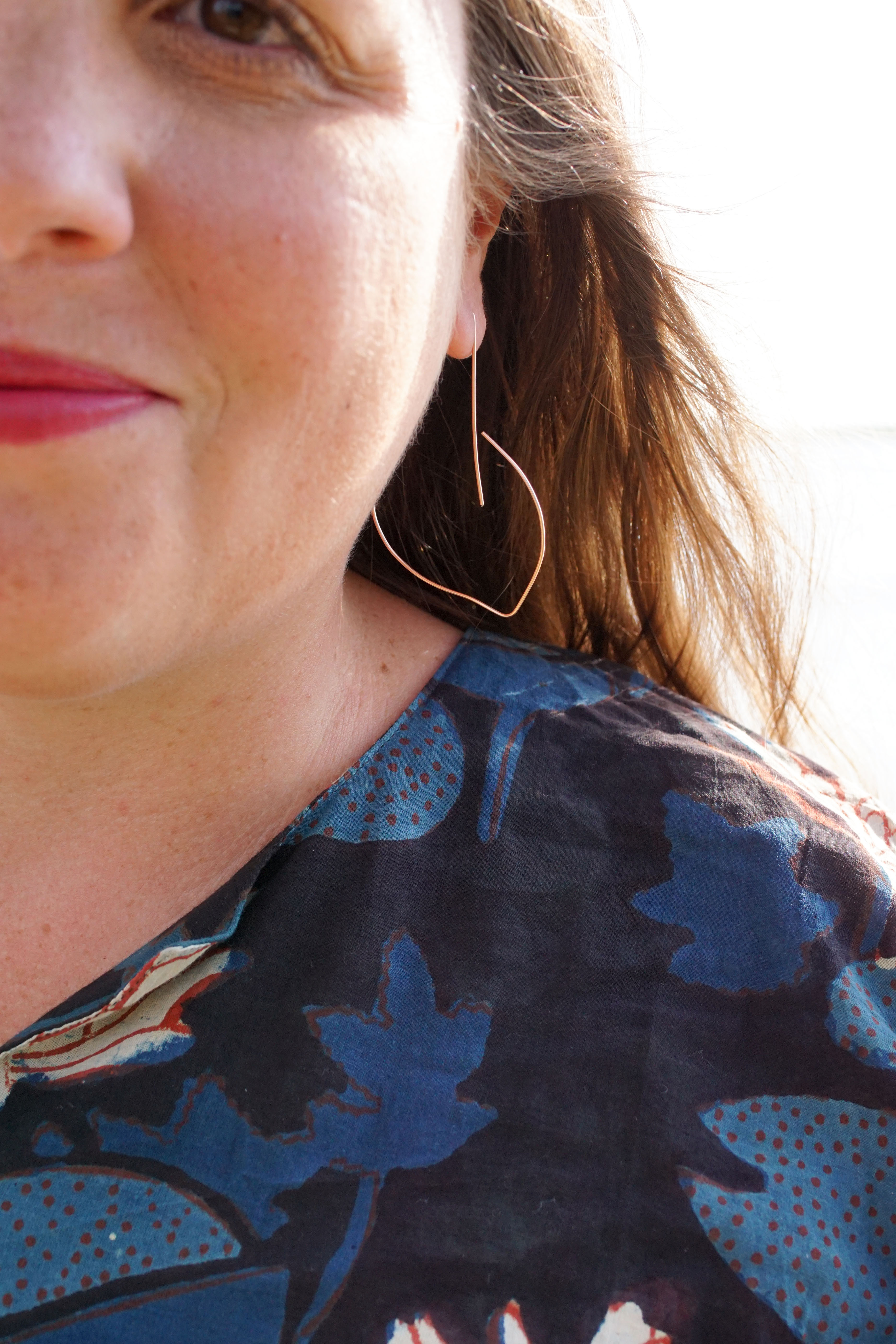 block-printed kaftan and rose gold threader hoop earrings at the beach