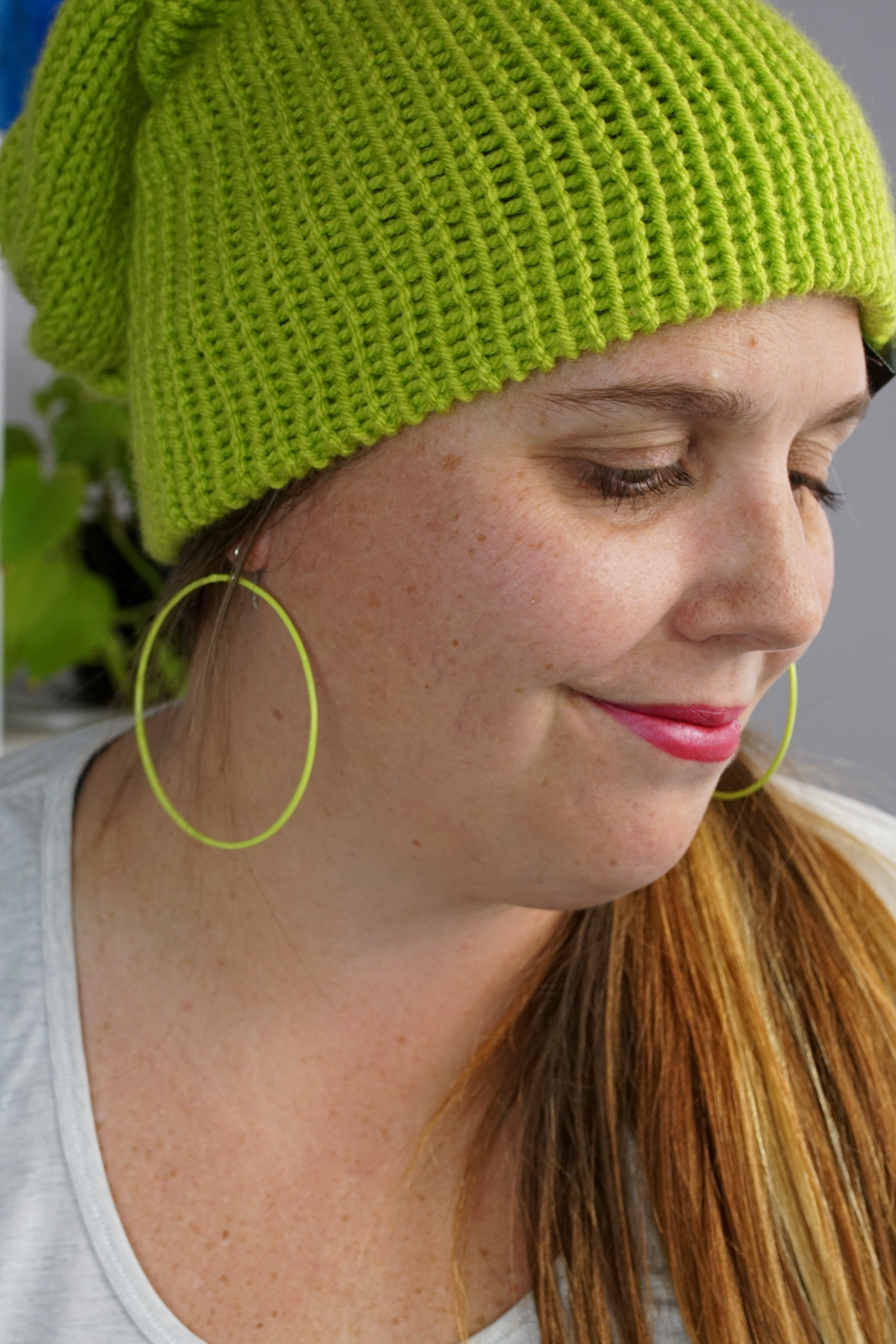 woman wearing neon knit hat and large neon hoop earrings