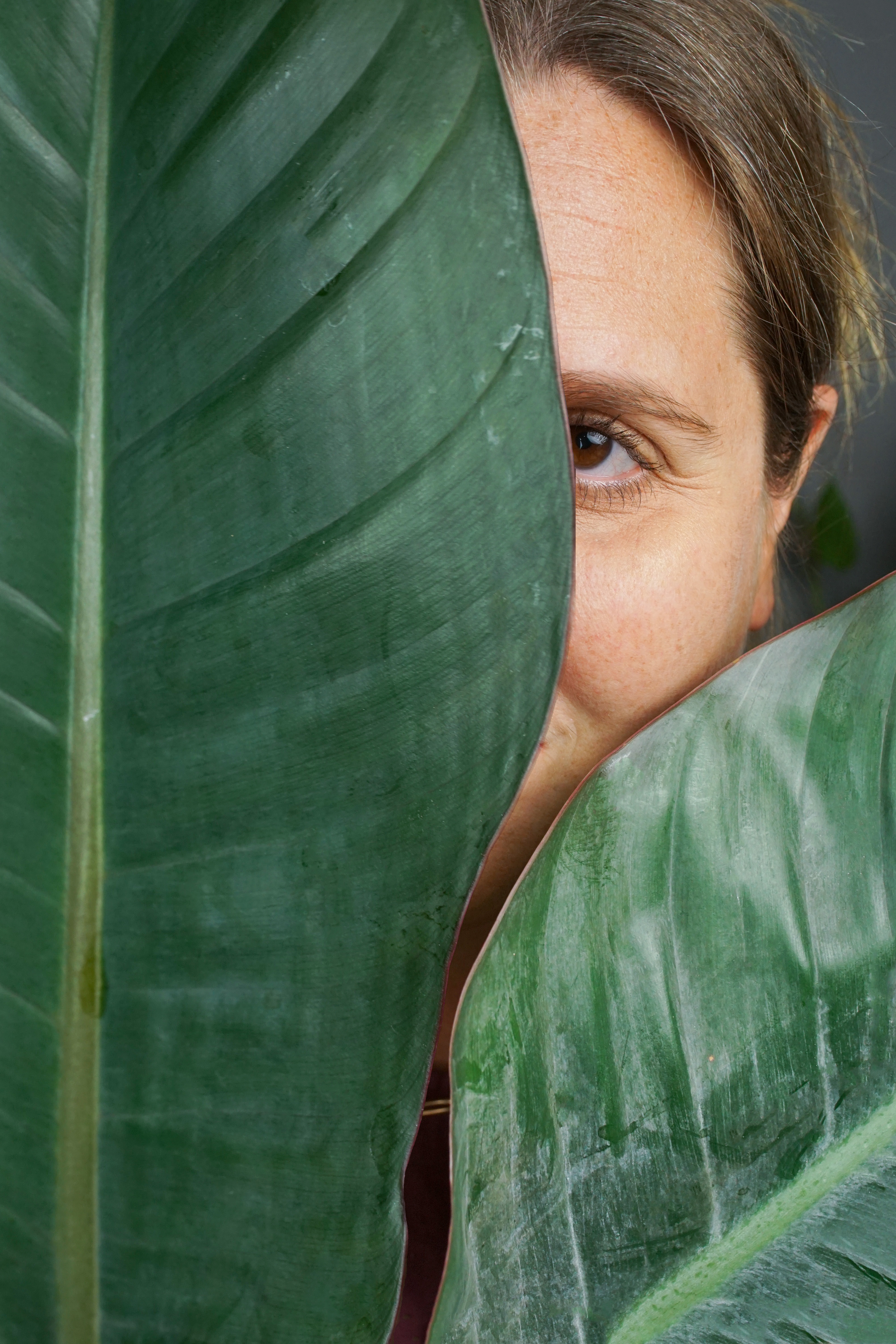 self-portrait of woman behind plant