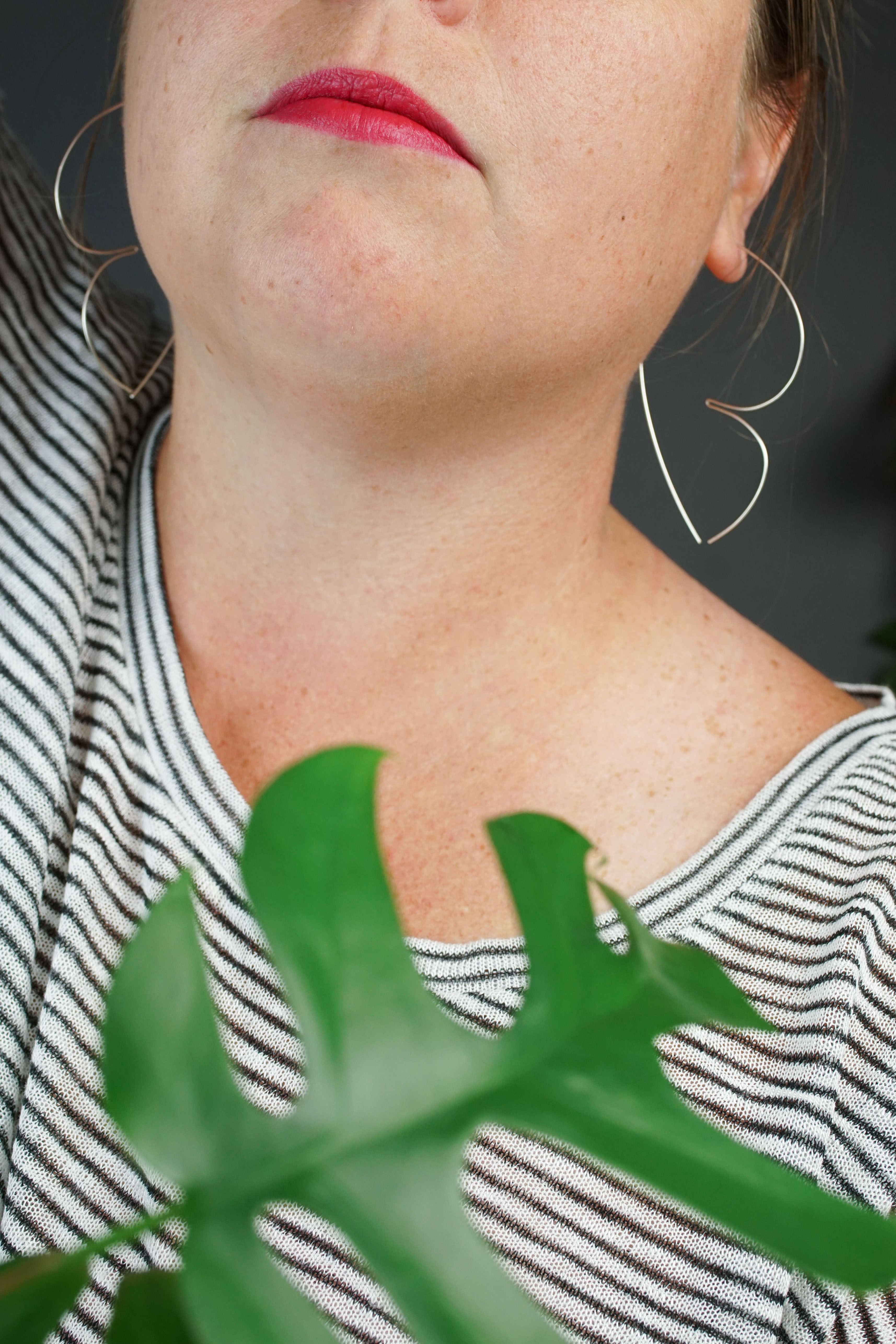 woman wearing unique silver threader hoop earrings and a striped shirt