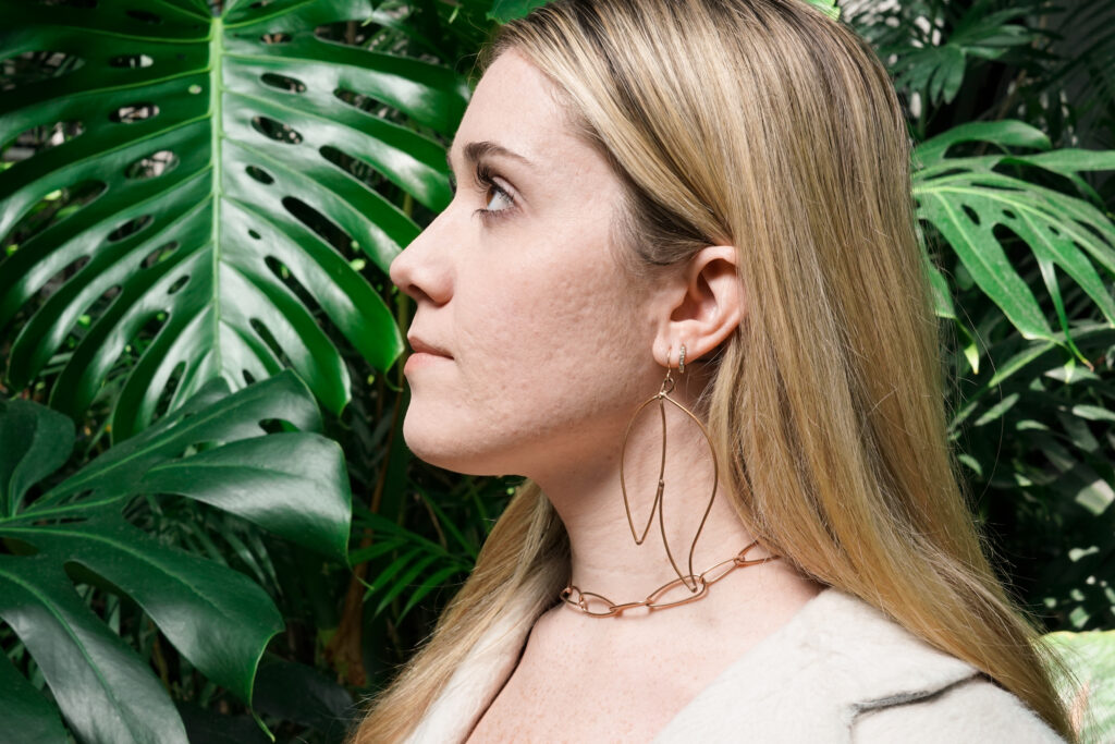 Trista with monstera leaves and bronze statement jewelry