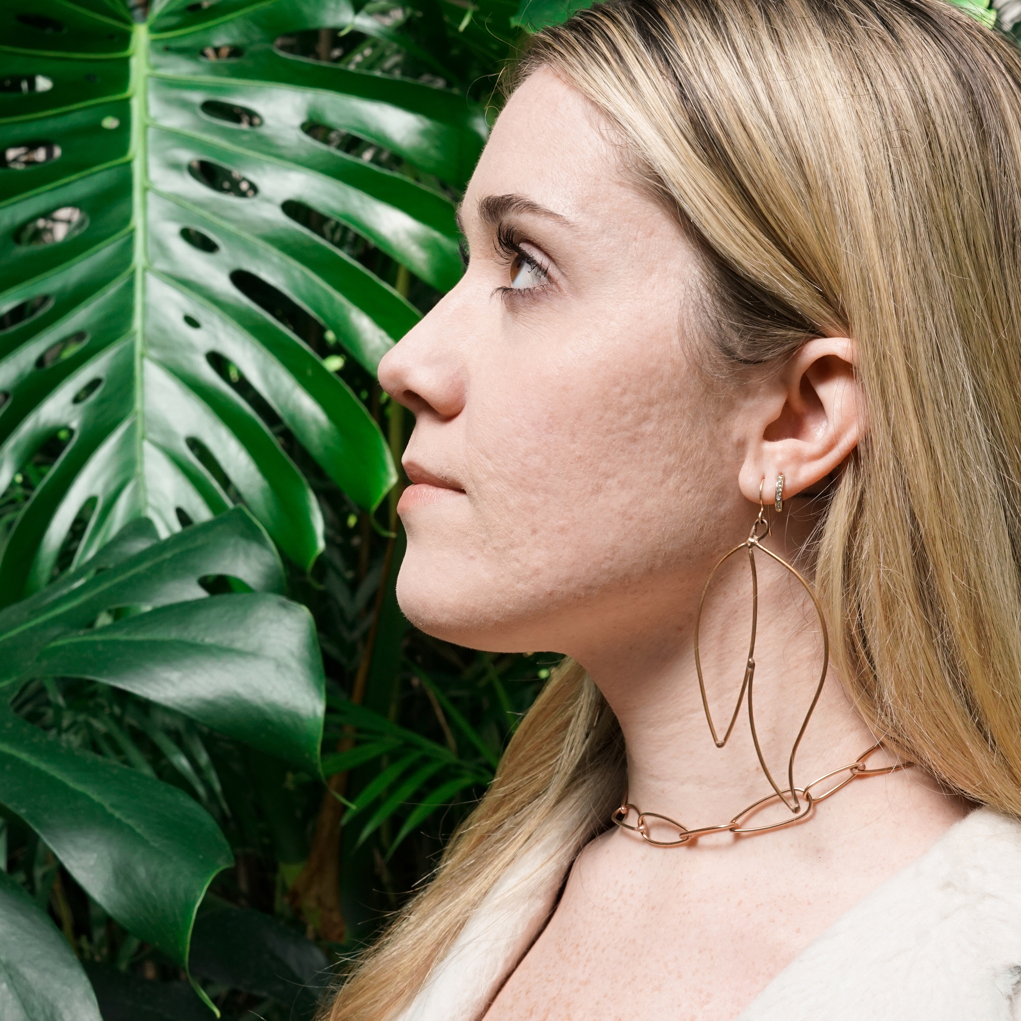 Trista with monstera leaves and bronze statement jewelry