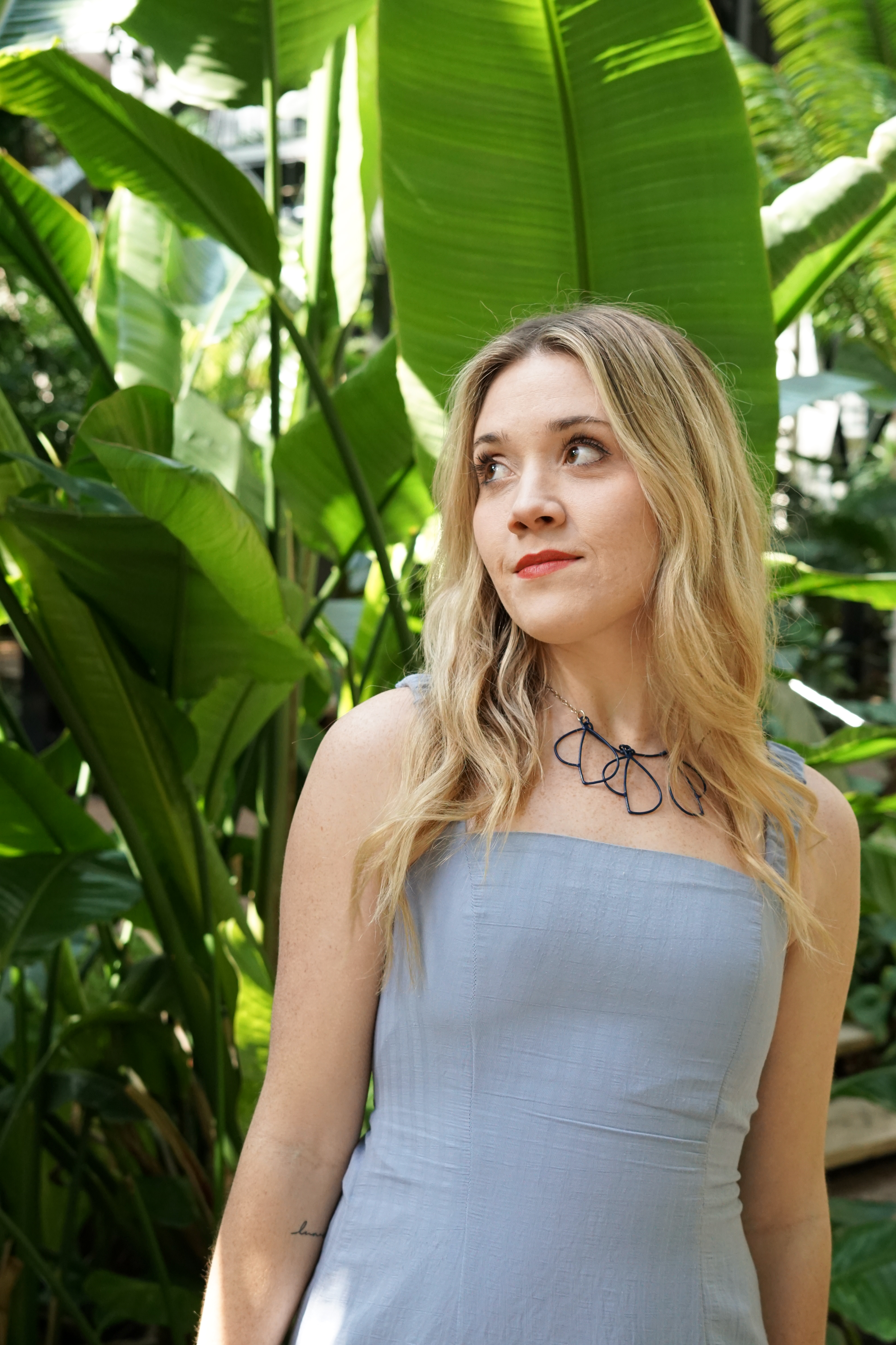 Trista in garden with blue dress and trivolo statement necklace