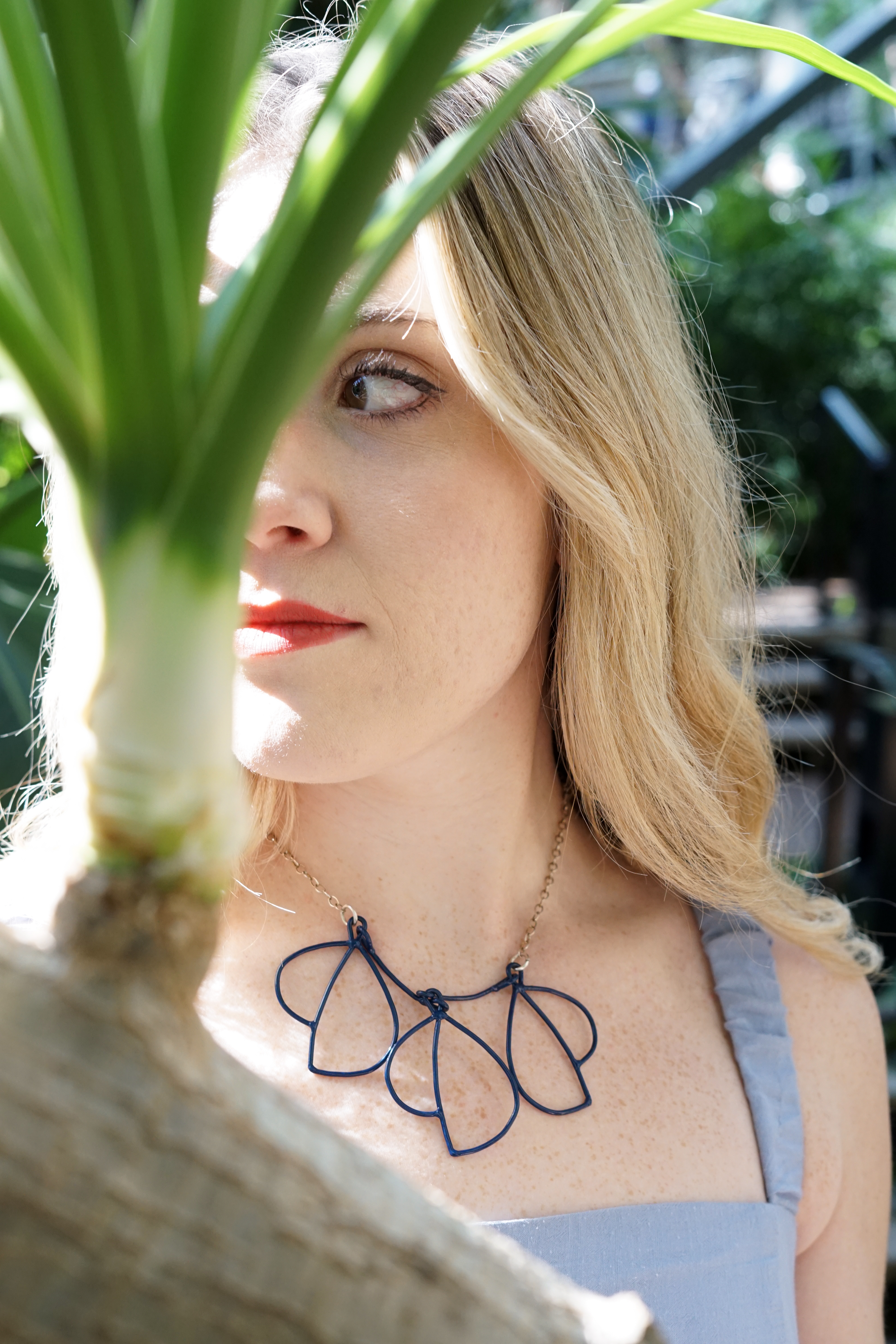 Trista in garden with blue dress and trivolo statement necklace