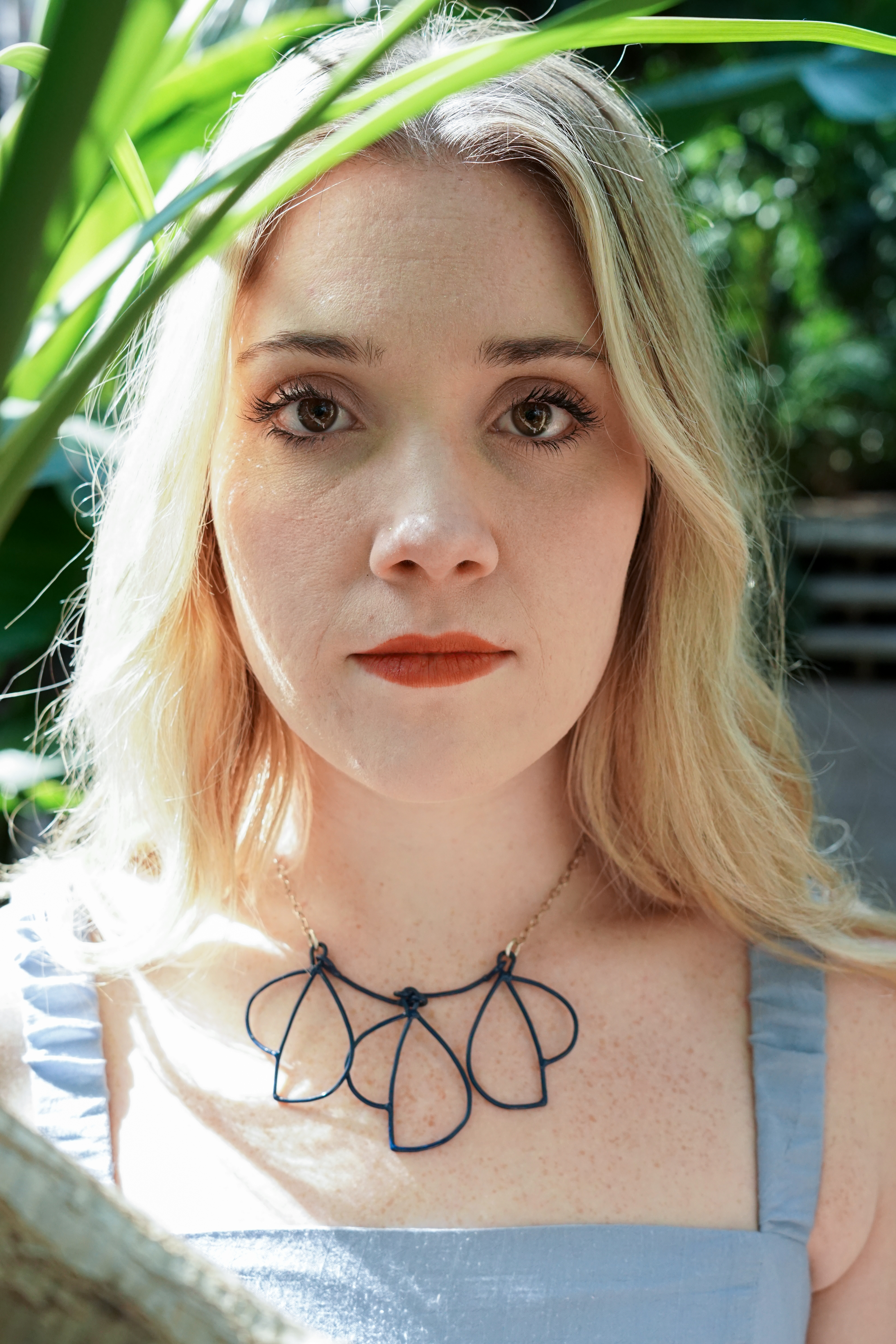 Trista in garden with blue dress and trivolo statement necklace