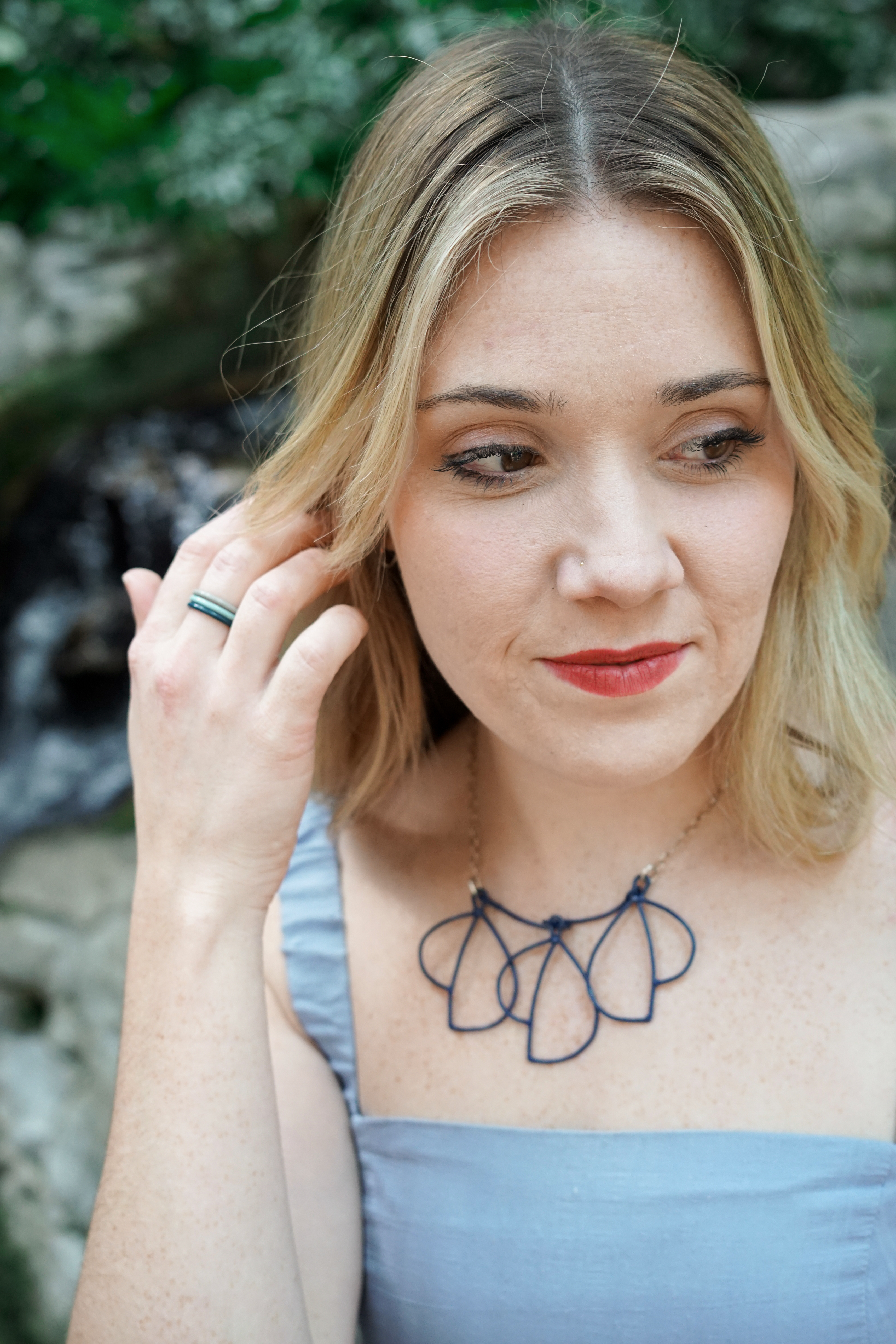 Trista in garden with blue dress and trivolo statement necklace