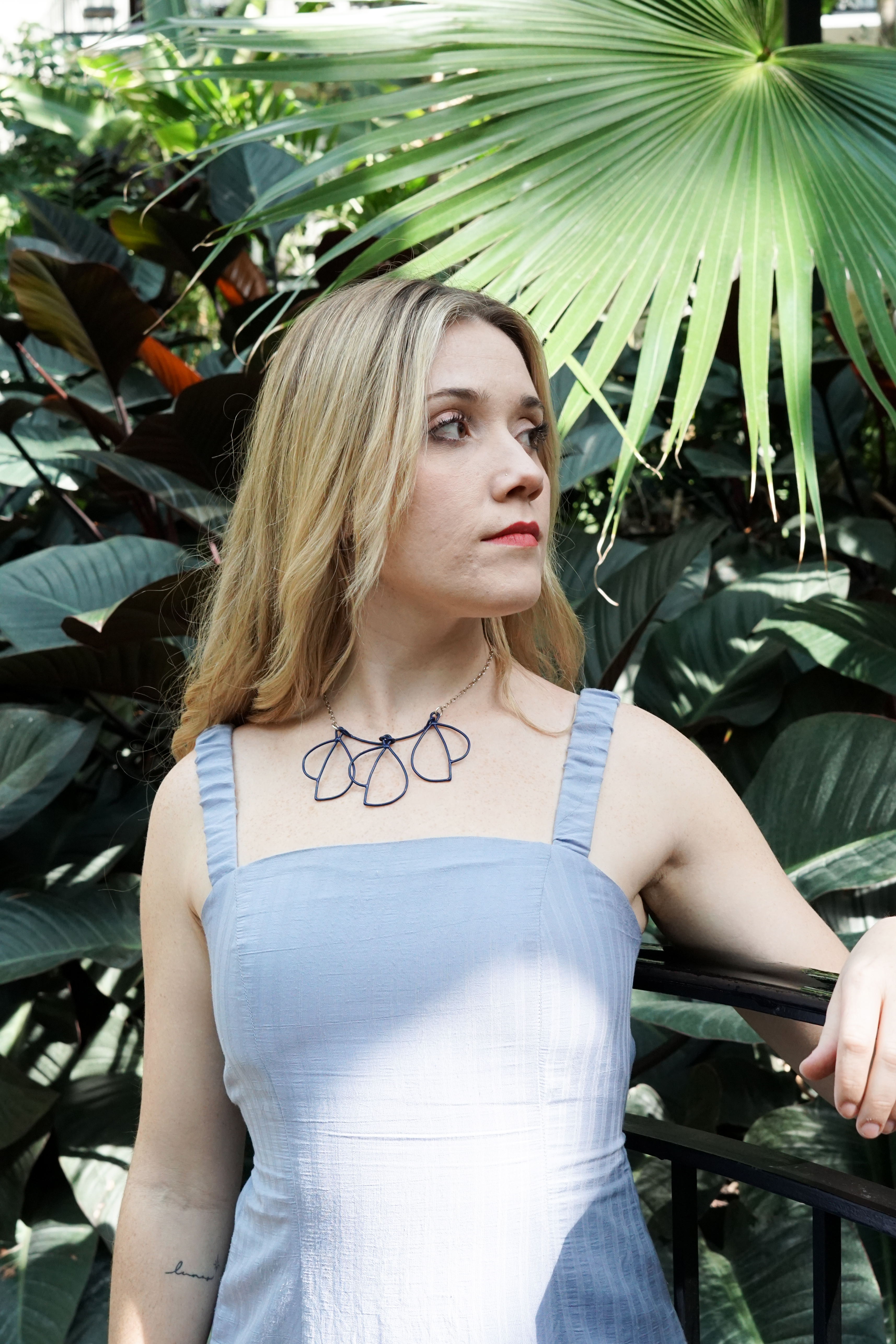 Trista in garden with blue dress and trivolo statement necklace