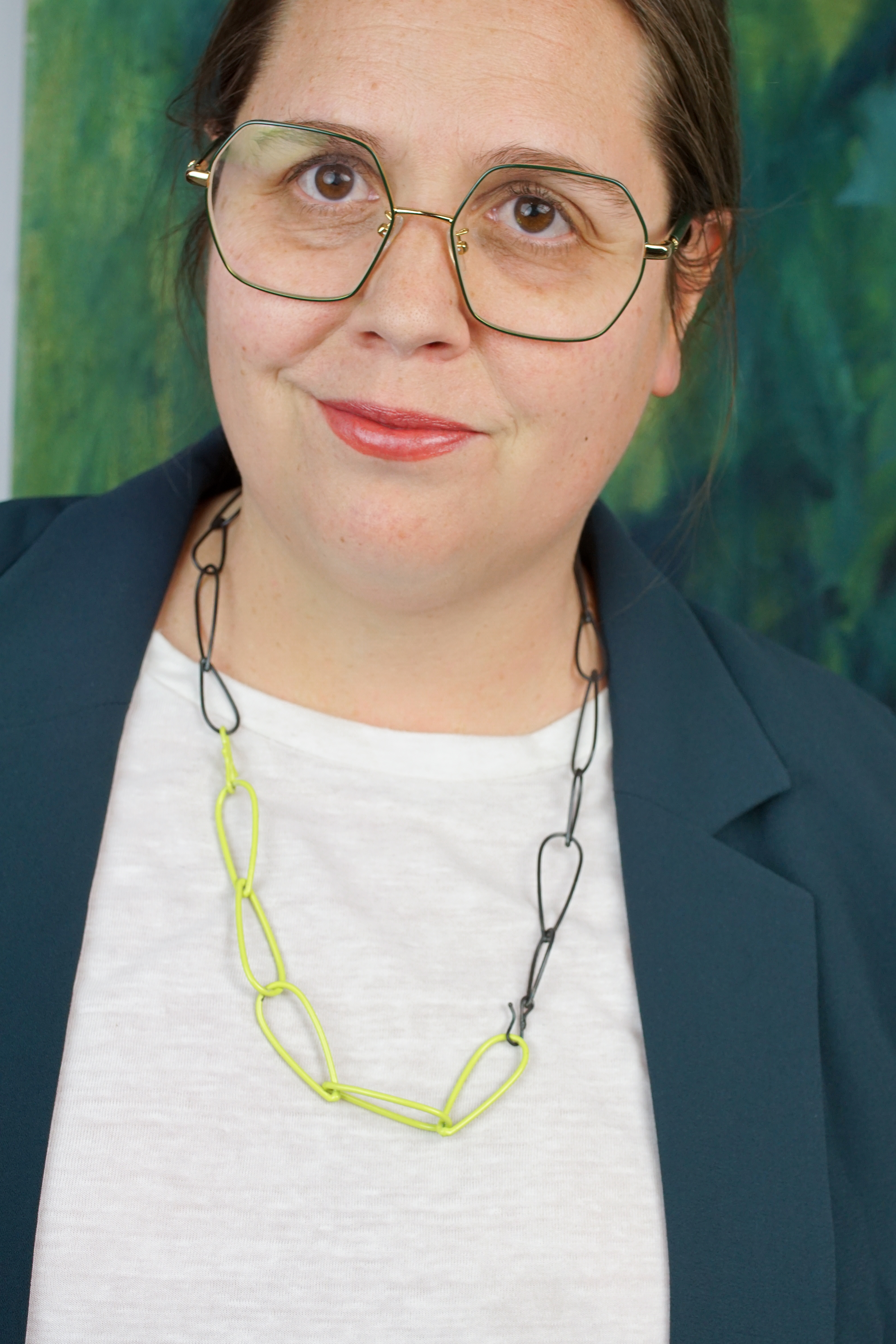 unique professional style:  neon necklace, white t-shirt, dark teal blazer, glasses