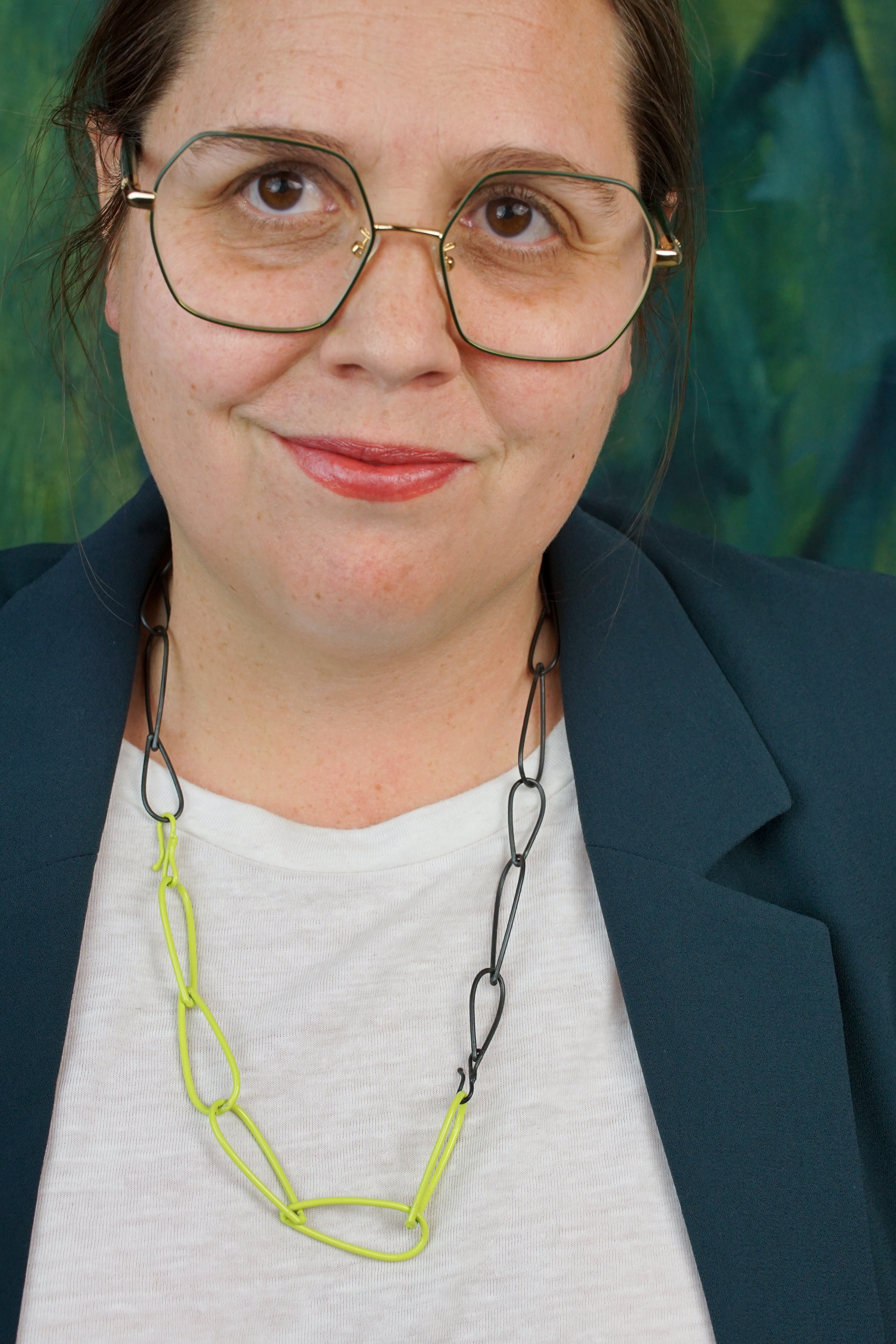 unique professional style:  neon necklace, white t-shirt, dark teal blazer, glasses