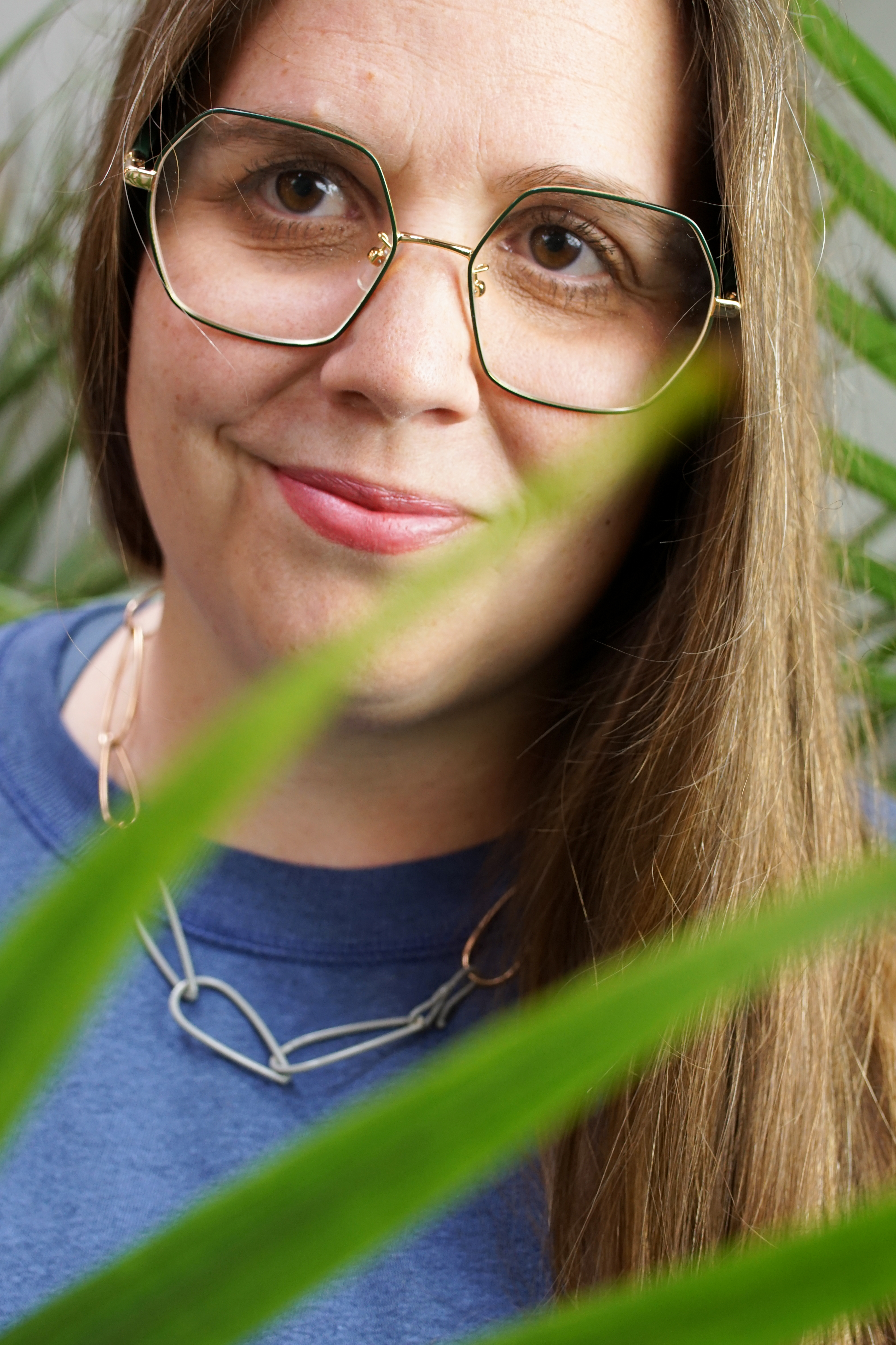 portrait with palm tree and chain link necklace with sweatshirt