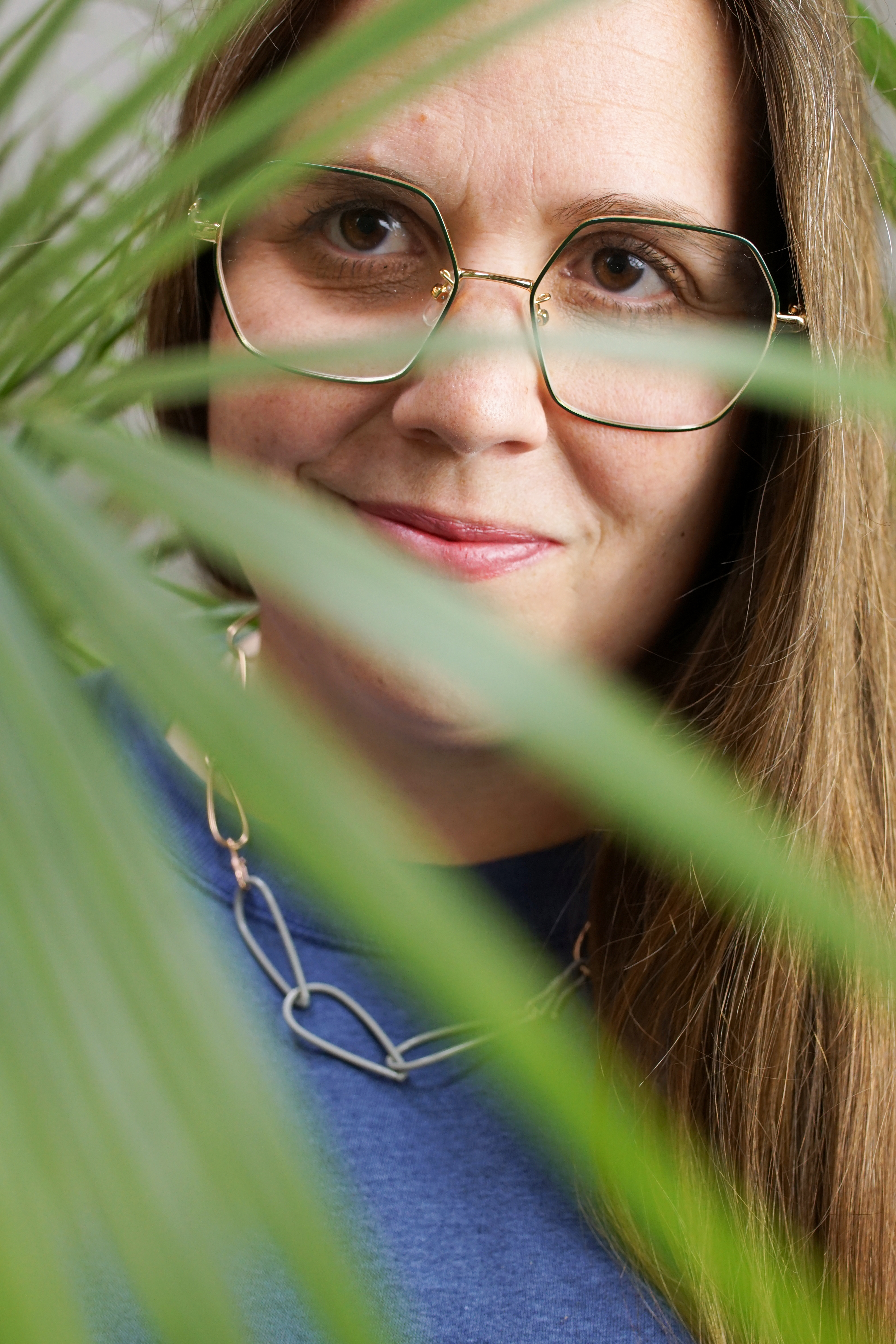 portrait with palm tree and chain link necklace with sweatshirt