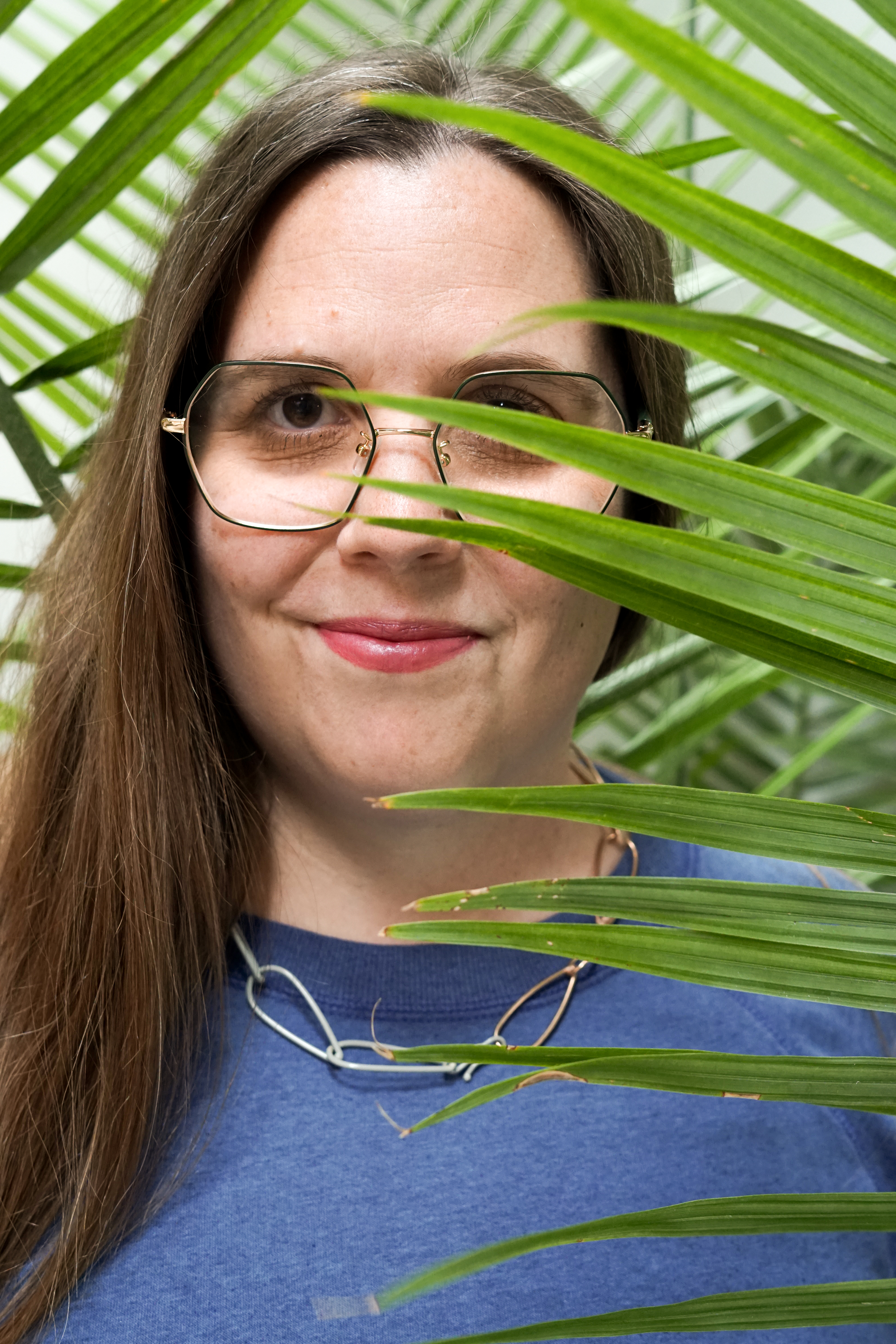 portrait with palm tree and chain link necklace with sweatshirt