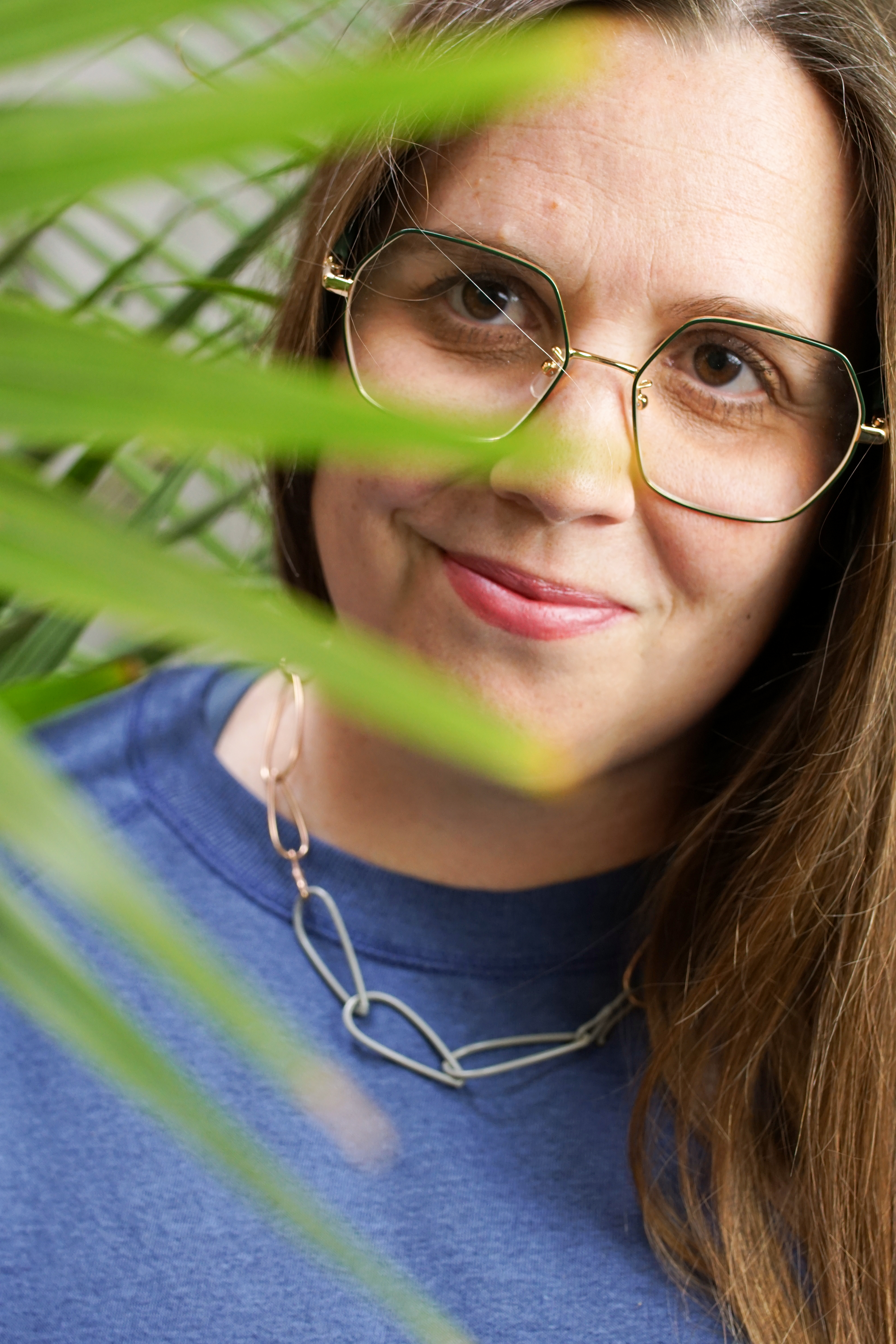 portrait with palm tree and chain link necklace with sweatshirt