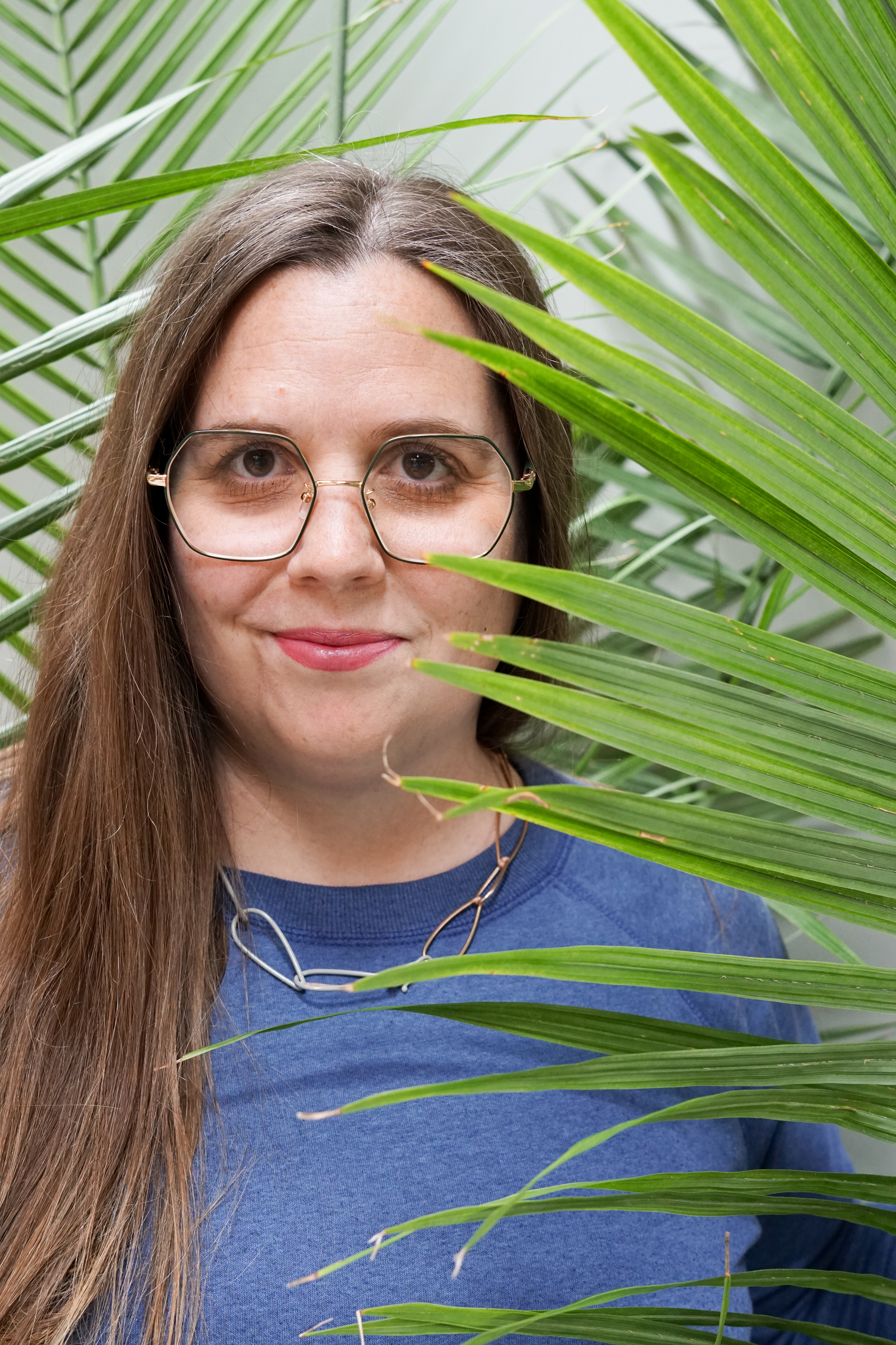 portrait with palm tree and chain link necklace with sweatshirt