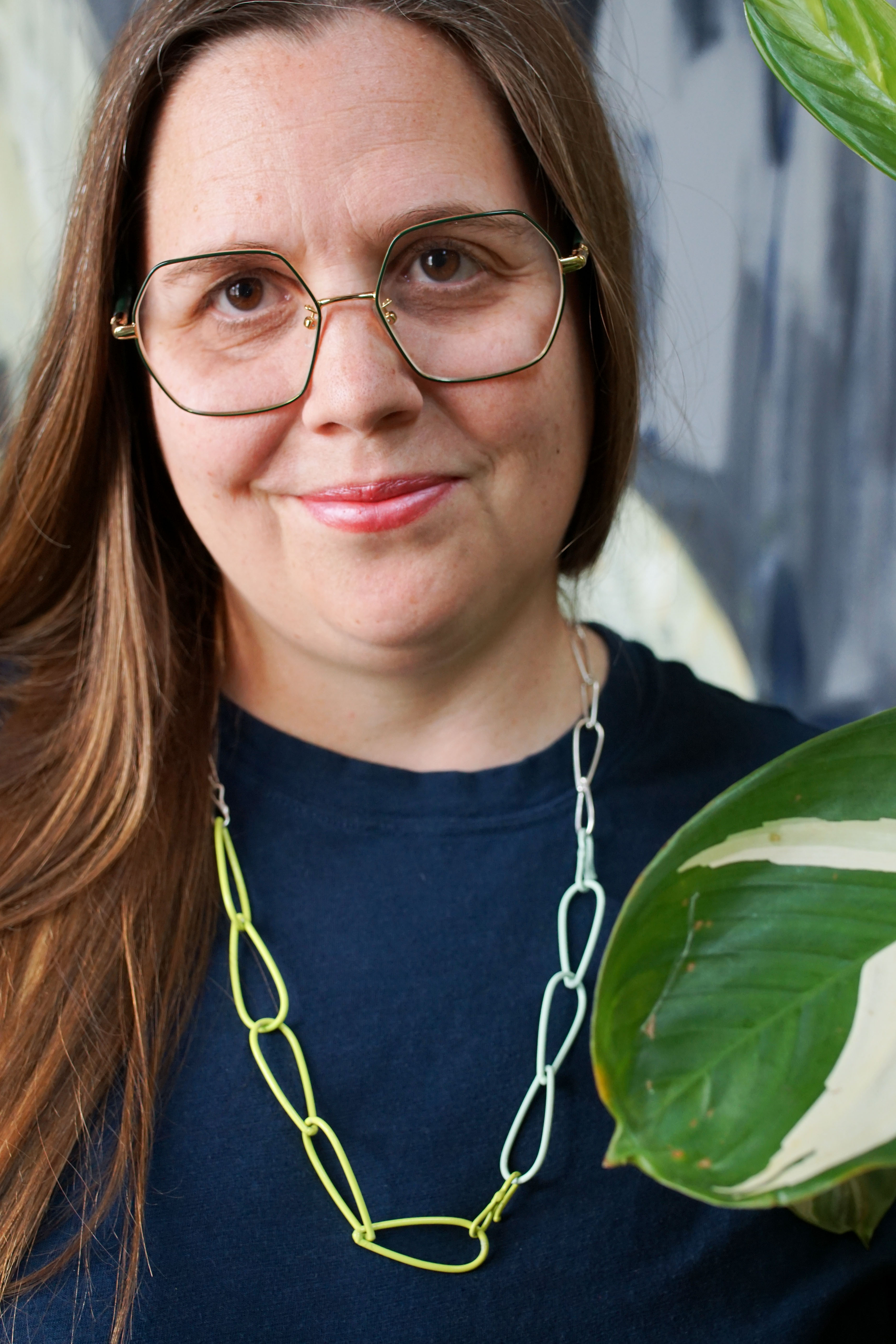 silver, neon, and mint necklace with dark teal t-shirt dress and plant