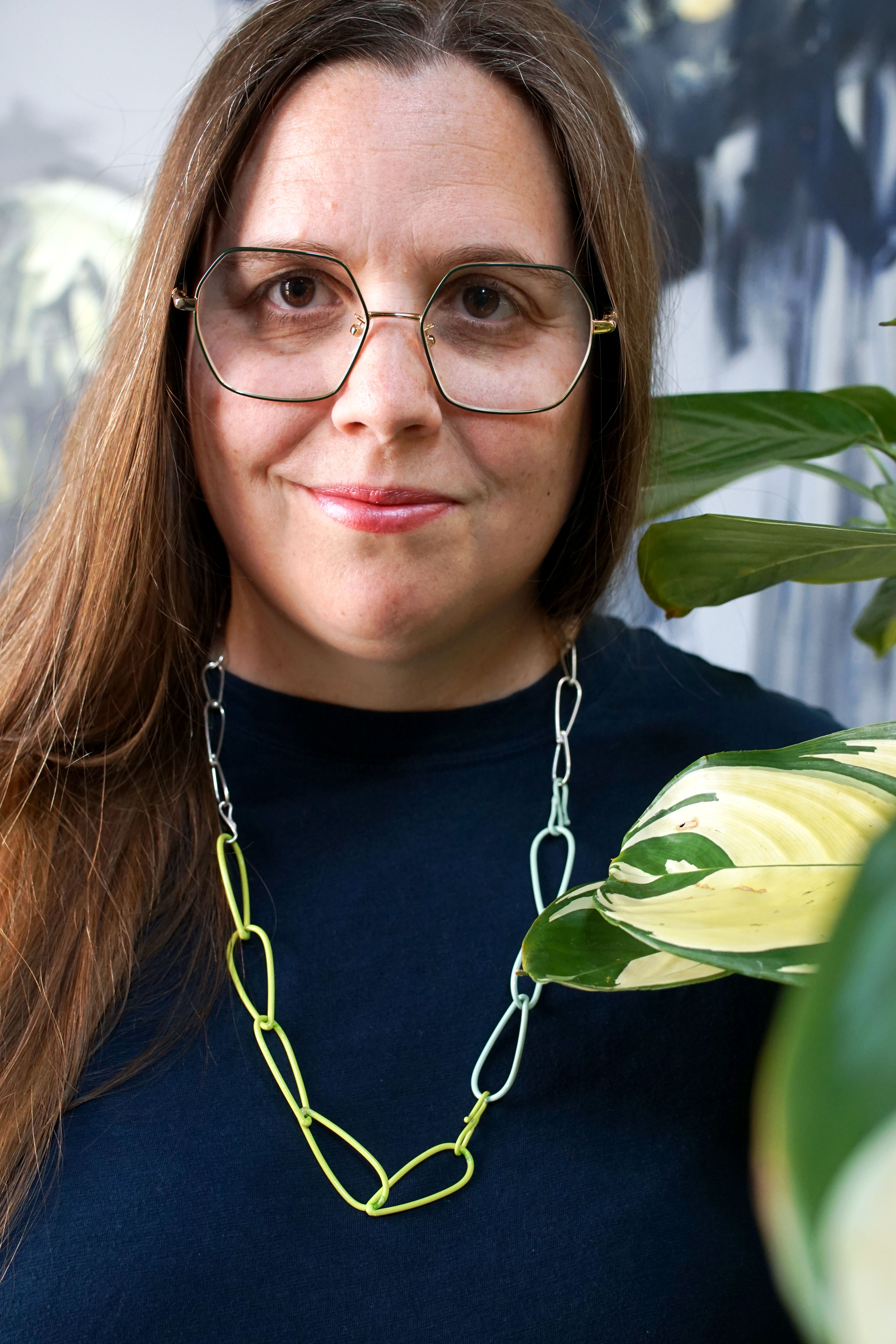 silver, neon, and mint necklace with dark teal t-shirt dress and plant