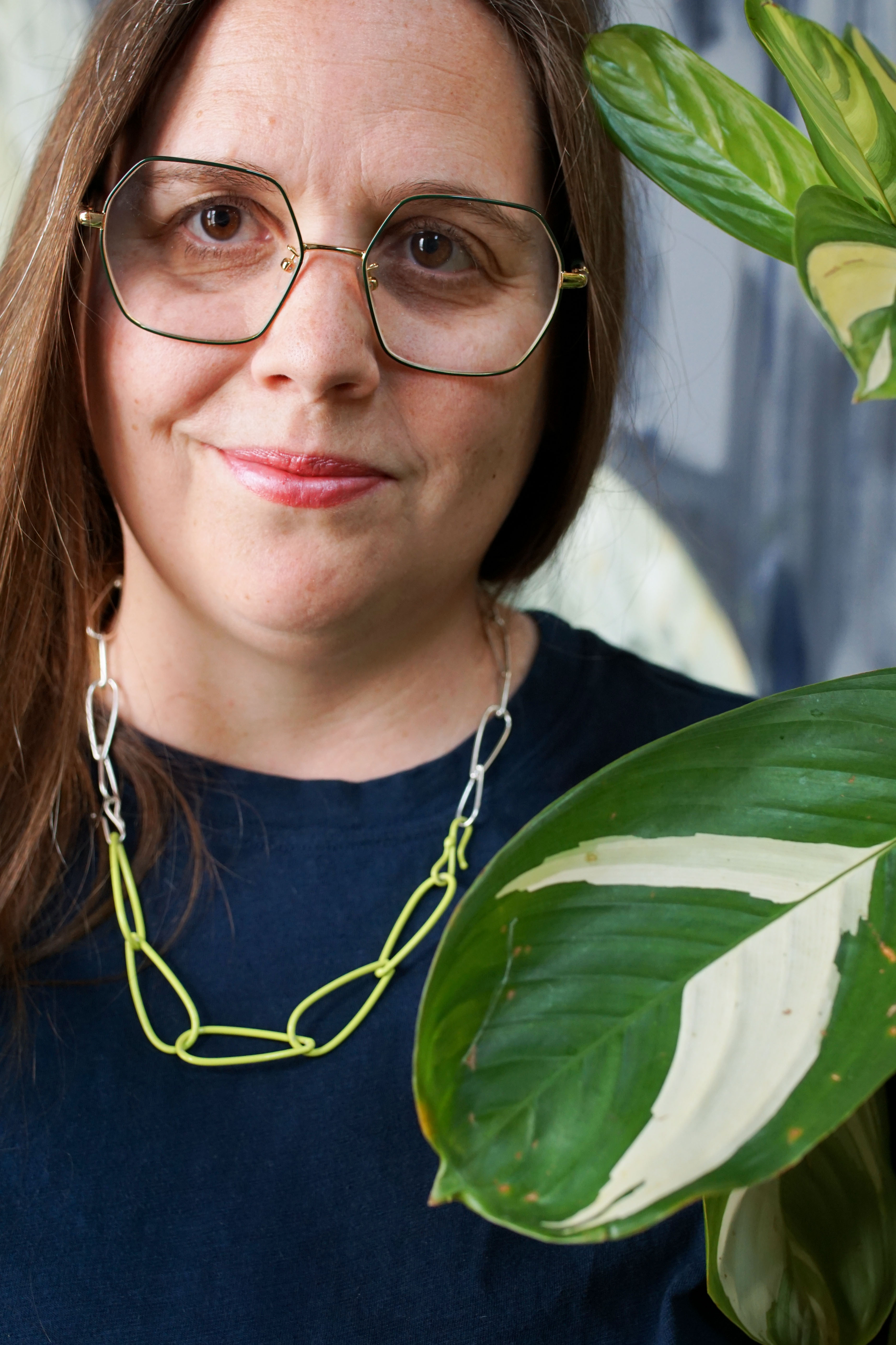 silver and neon necklace with dark teal t-shirt dress and plant