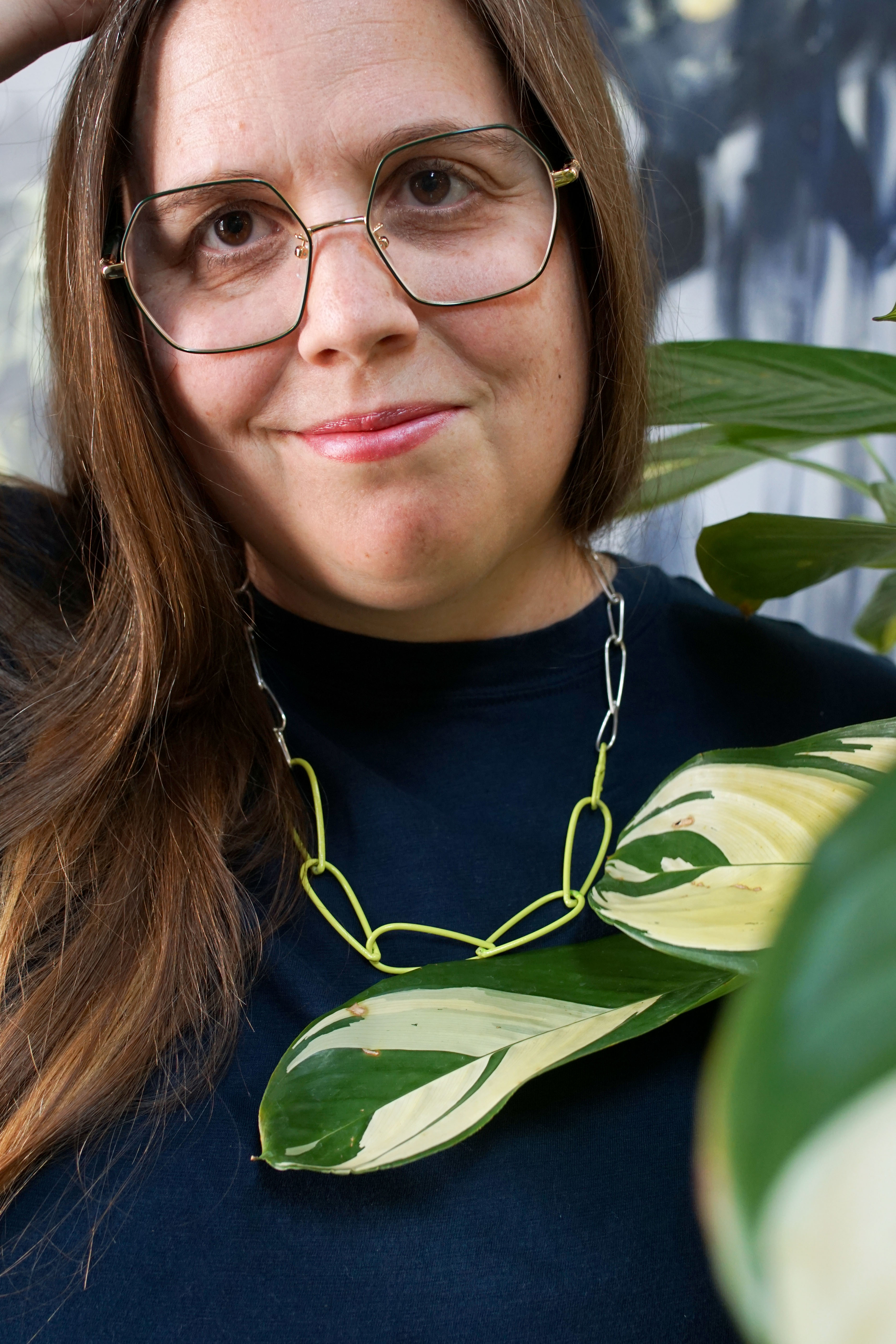 silver and neon necklace with dark teal t-shirt dress and plant