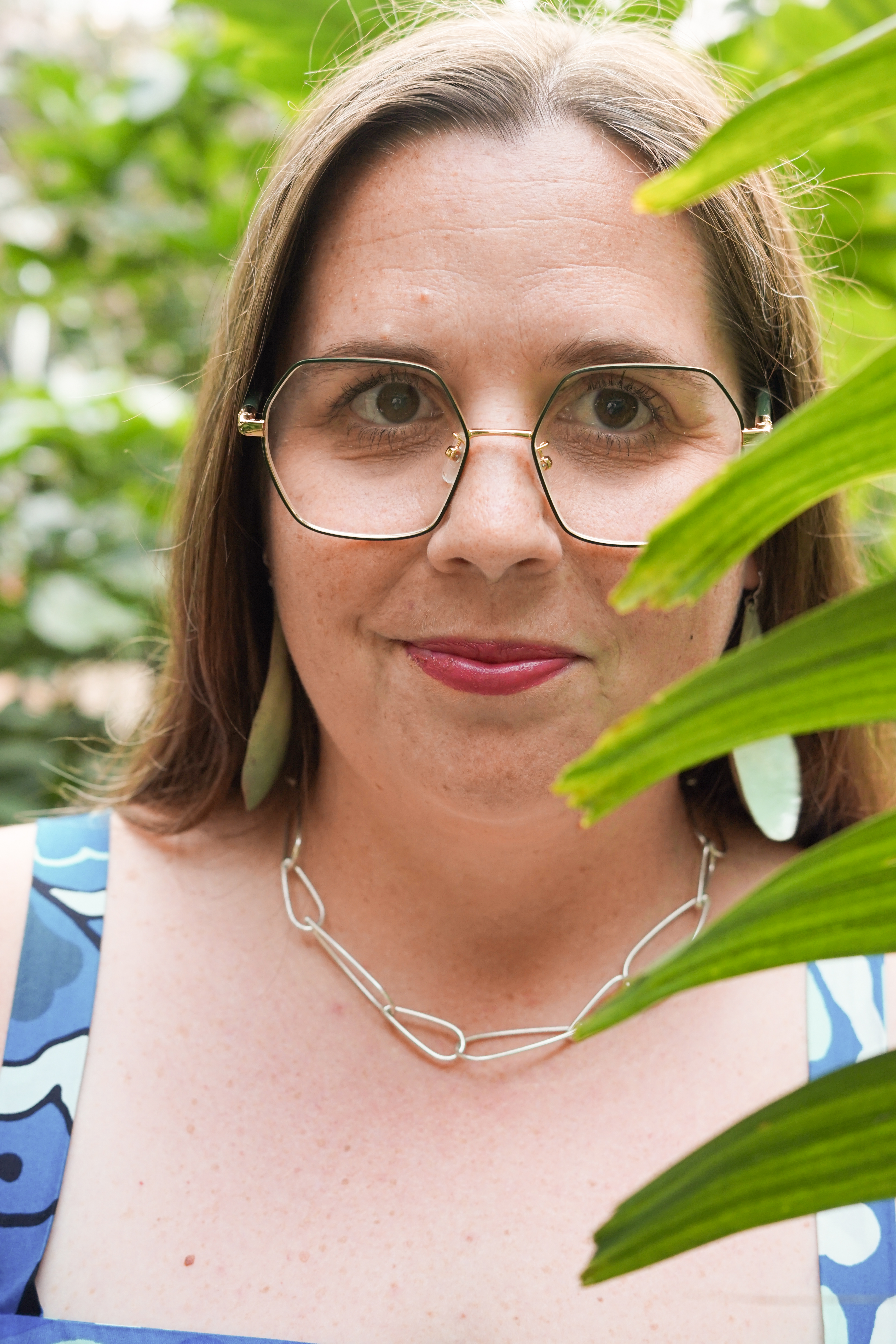 portraits with plants with statement earrings and chunky silver chain necklace