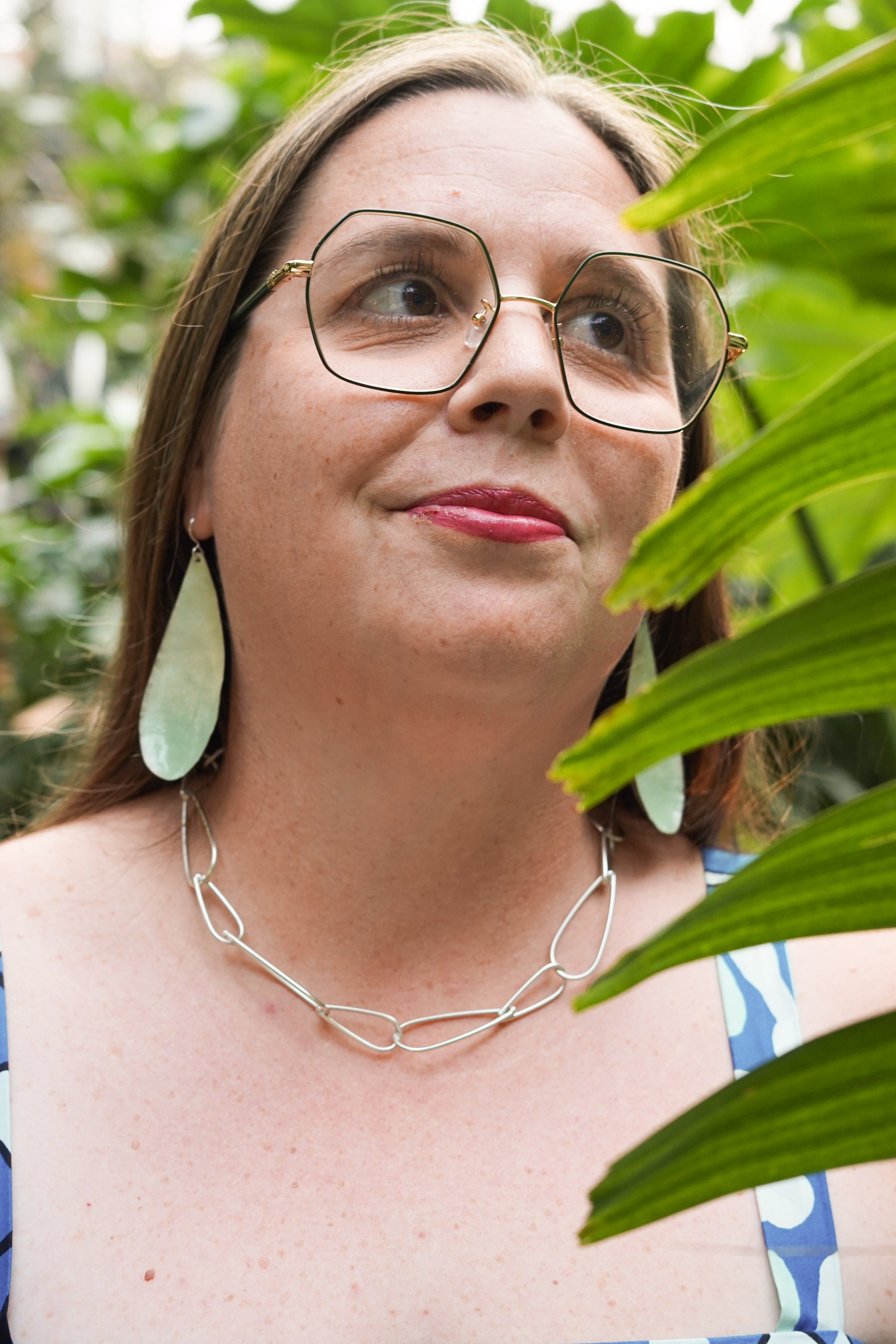 portraits with plants with statement earrings and chunky silver chain necklace