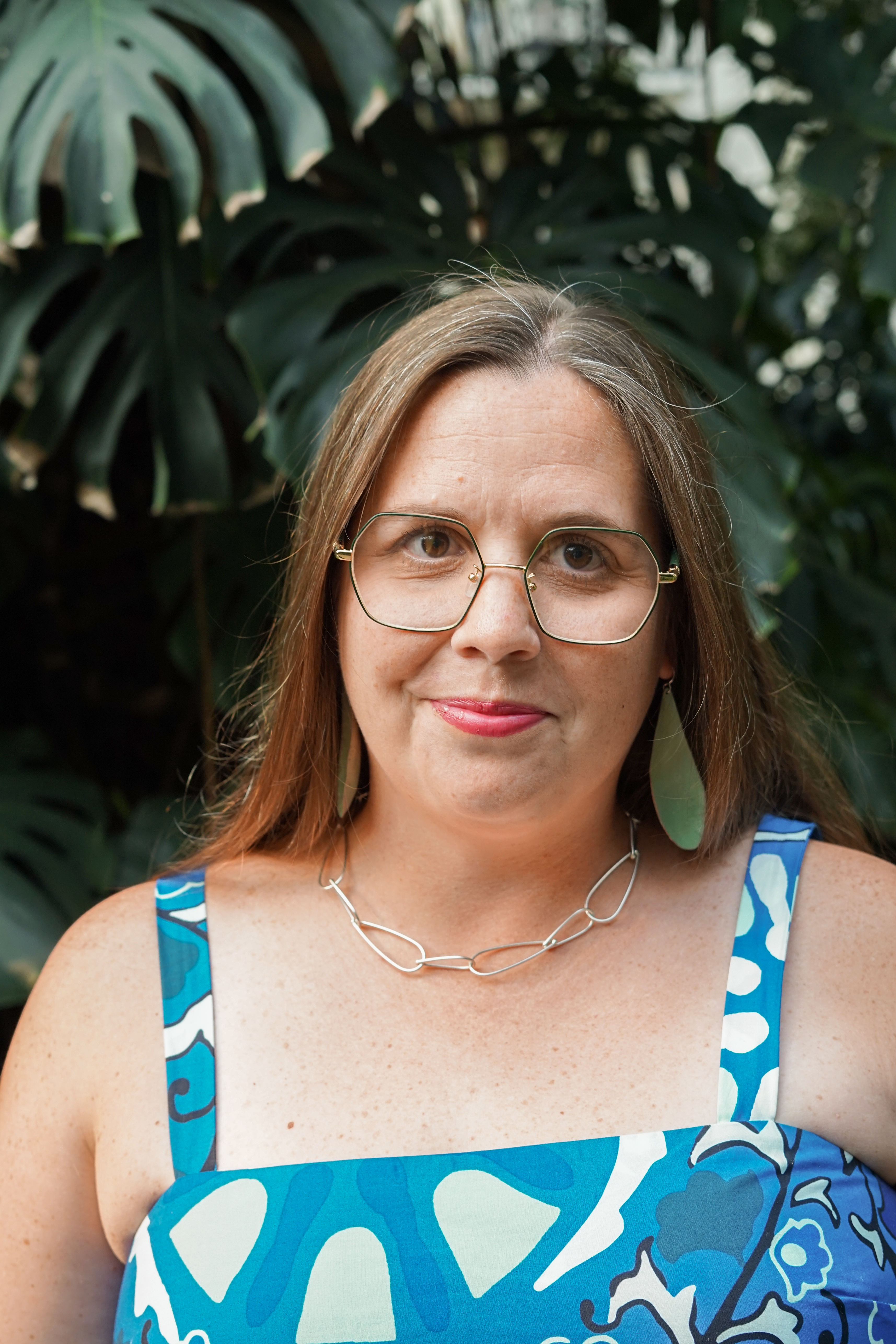 portraits with plants with statement earrings and chunky silver chain necklace