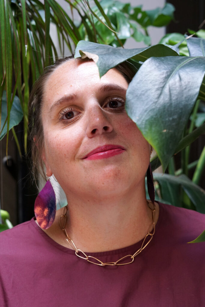 portrait with monstera - fall style jewelry and burgundy dress with bronze chain necklace