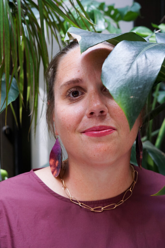 portrait with monstera - fall style jewelry and burgundy dress with bronze chain necklace